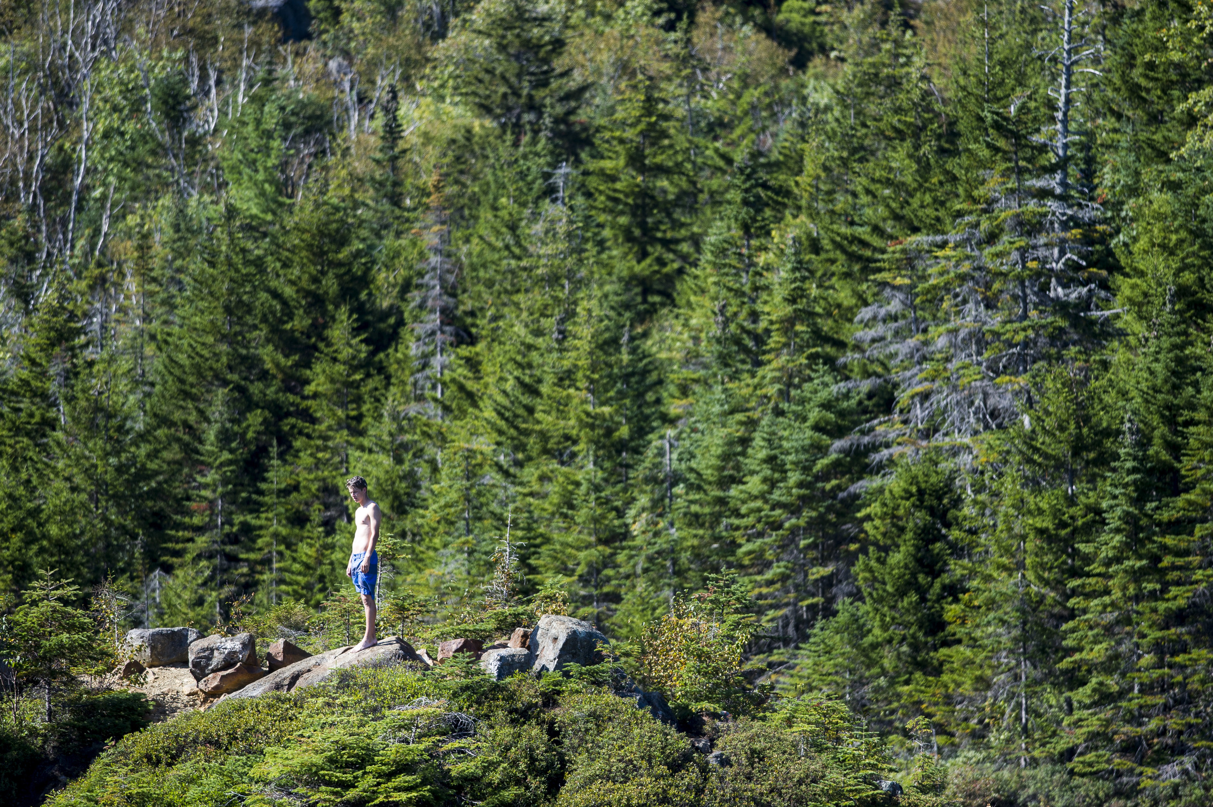 William Sanders '19 of Arlington, Mass. explores a small island within the lake atop Tumbledown Mountain.