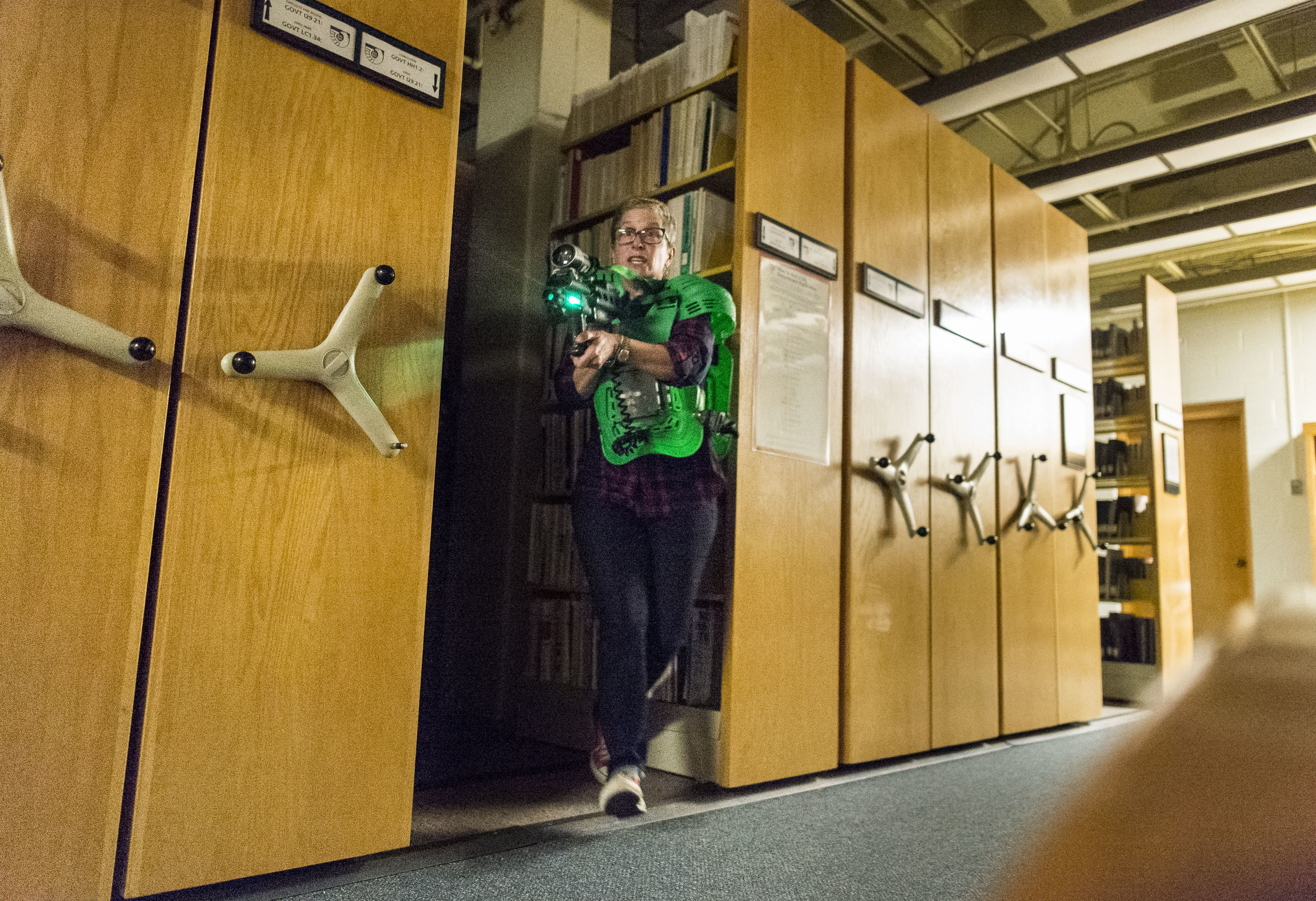  Assistant Vice President of Dining Christine Schwartz springs out from her hiding spot as students, faculty and staff came together to play Lazertag, darting and dodging between the many volumes of Ladd Library. 