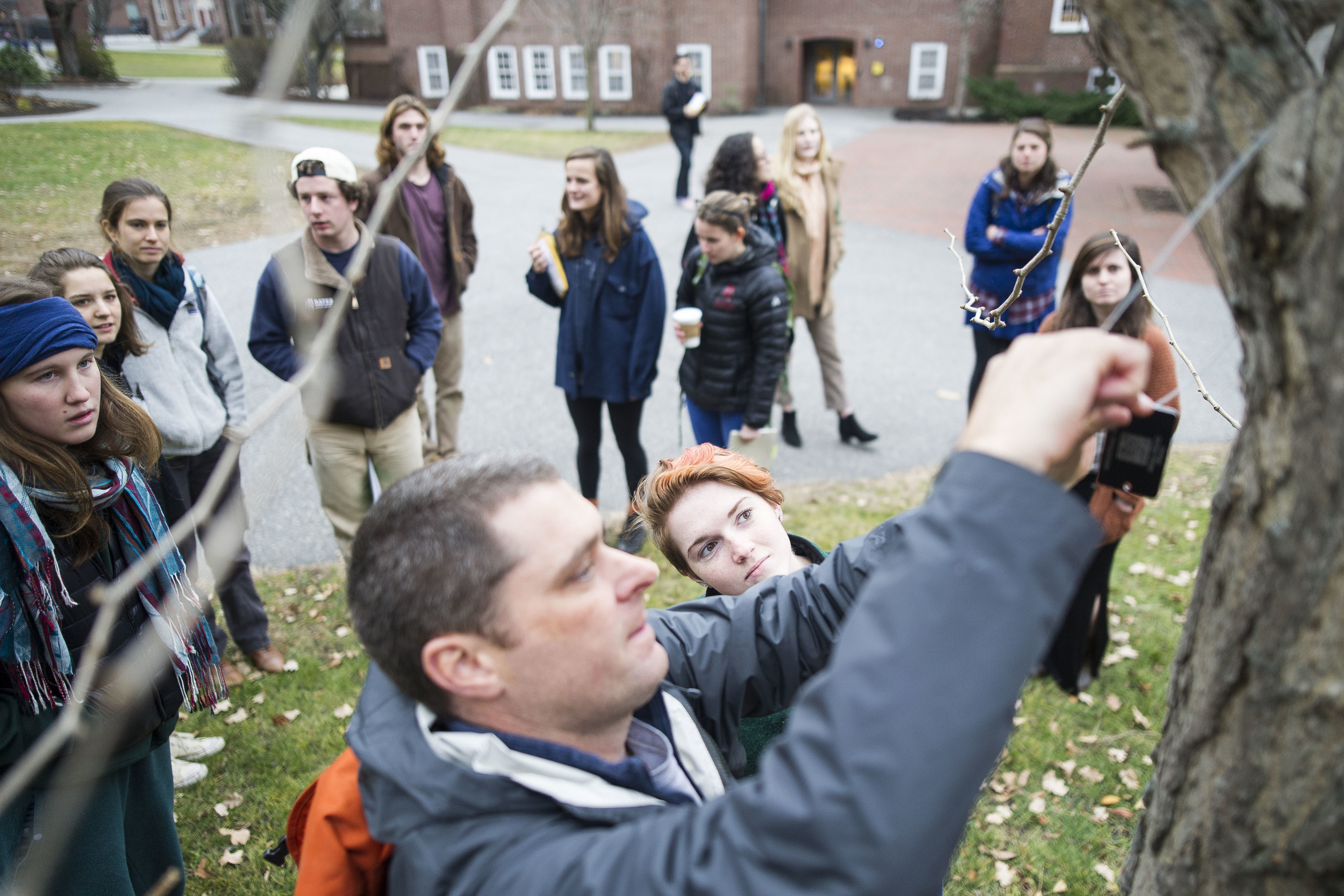  Rebecca Leloudis '16 of Chapel Hill, NC watches as Professor Brett Huggett hangs a tree tag. Students in Brett Huggett's class complete their semester long project of mapping and tagging all of the trees on the Historic Quad. 