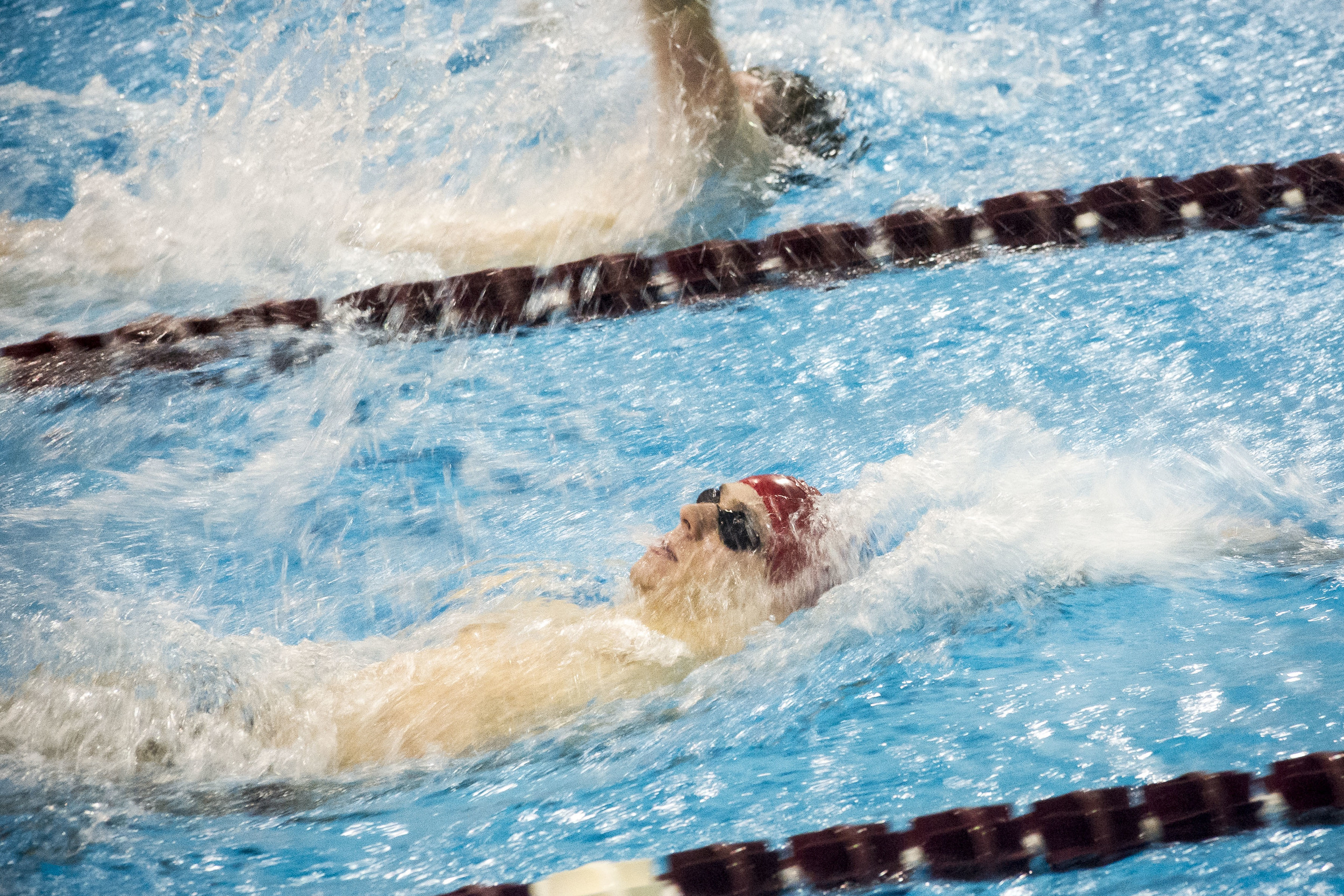 Zachary Collester '19 approaches the finish of the 100 backstroke against Trinity at Tarbell Pool.