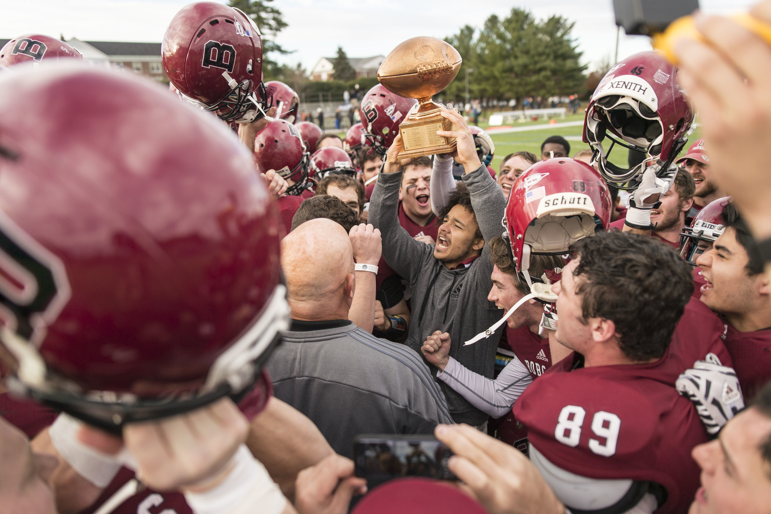 Shaun Carroll '16 holds up the CBB (Colby-Bates-Bowdoin) Championship trophy his teammates fought to retain after Bates' 31-0 win over Bowdoin College.