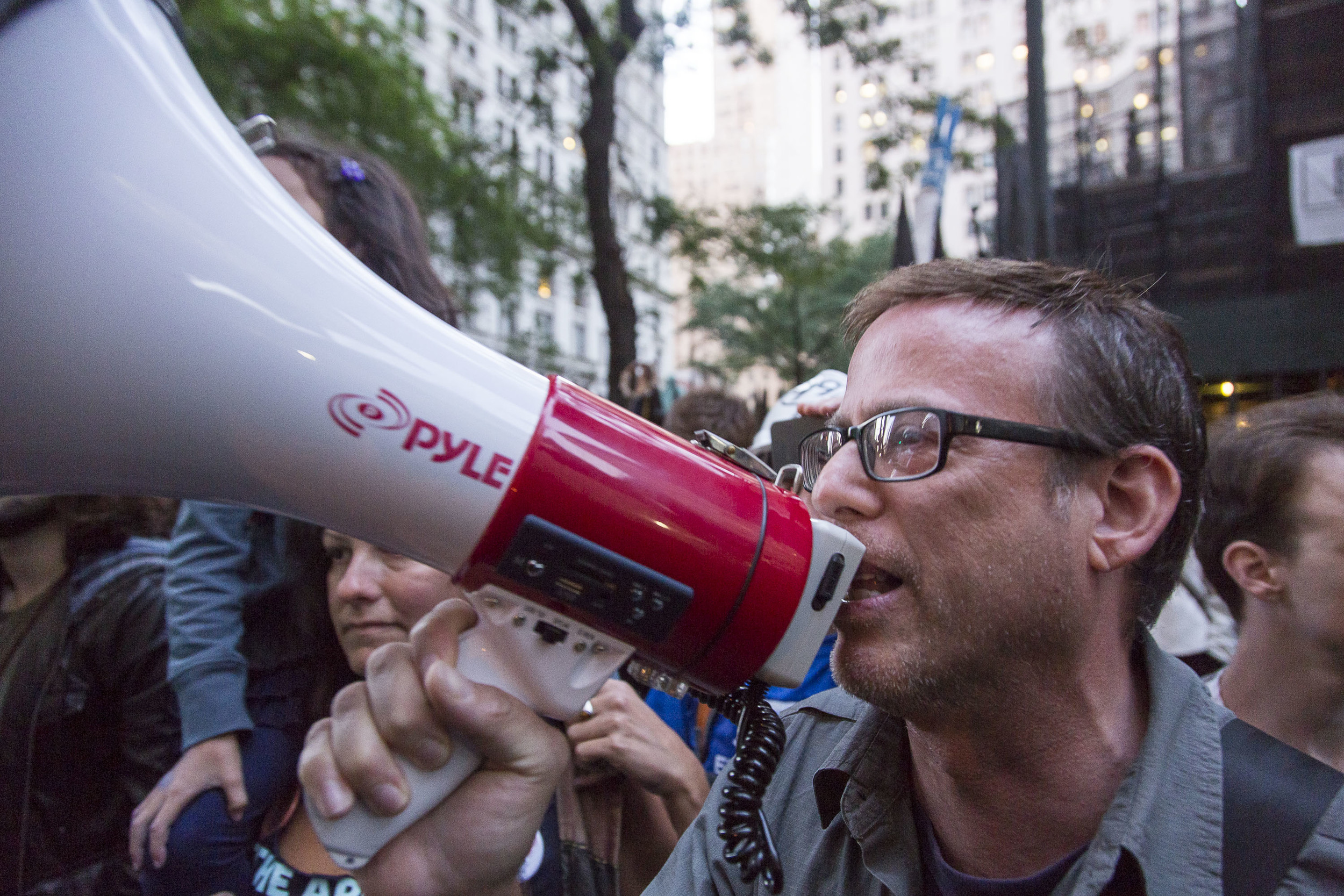  A protestor armed with a megaphone outside Trinity Church on the corner of Broadway and Wall Street. 