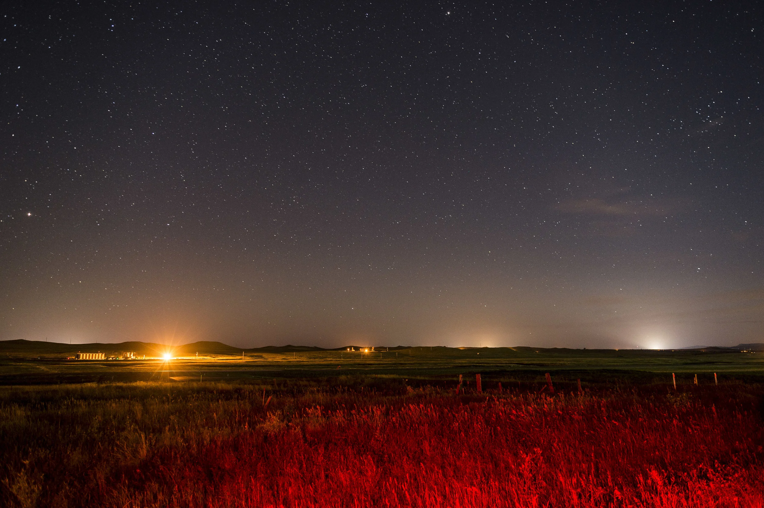 Oil pads (orange) and fracking sites (white) dot the landscape under the stars near Killdeer. 
