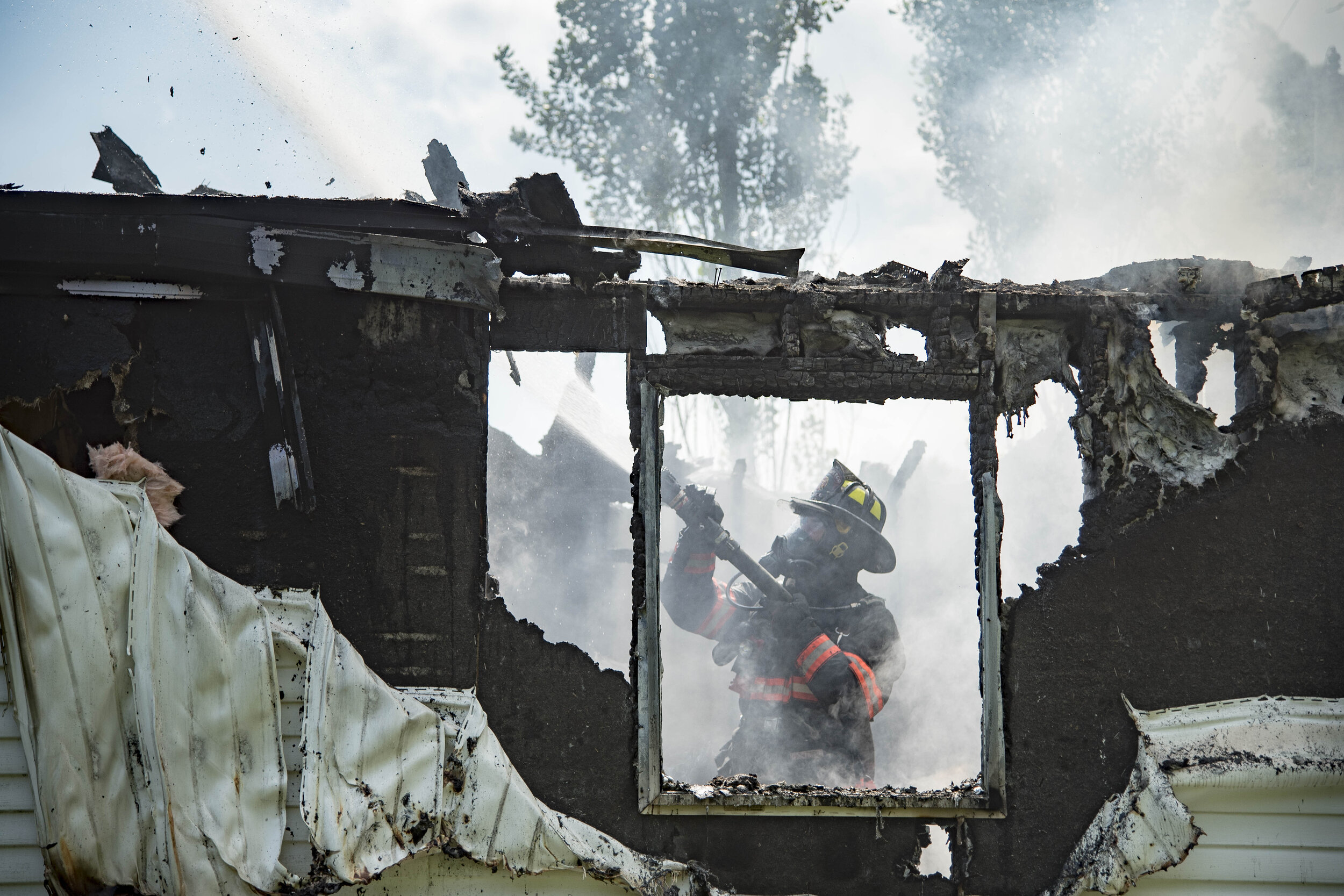  A Barre firefighter responds to a fire on Railroad Street in Williamstown, VT on Monday, August 6th 2018. No residents were home at the time of the fire.    