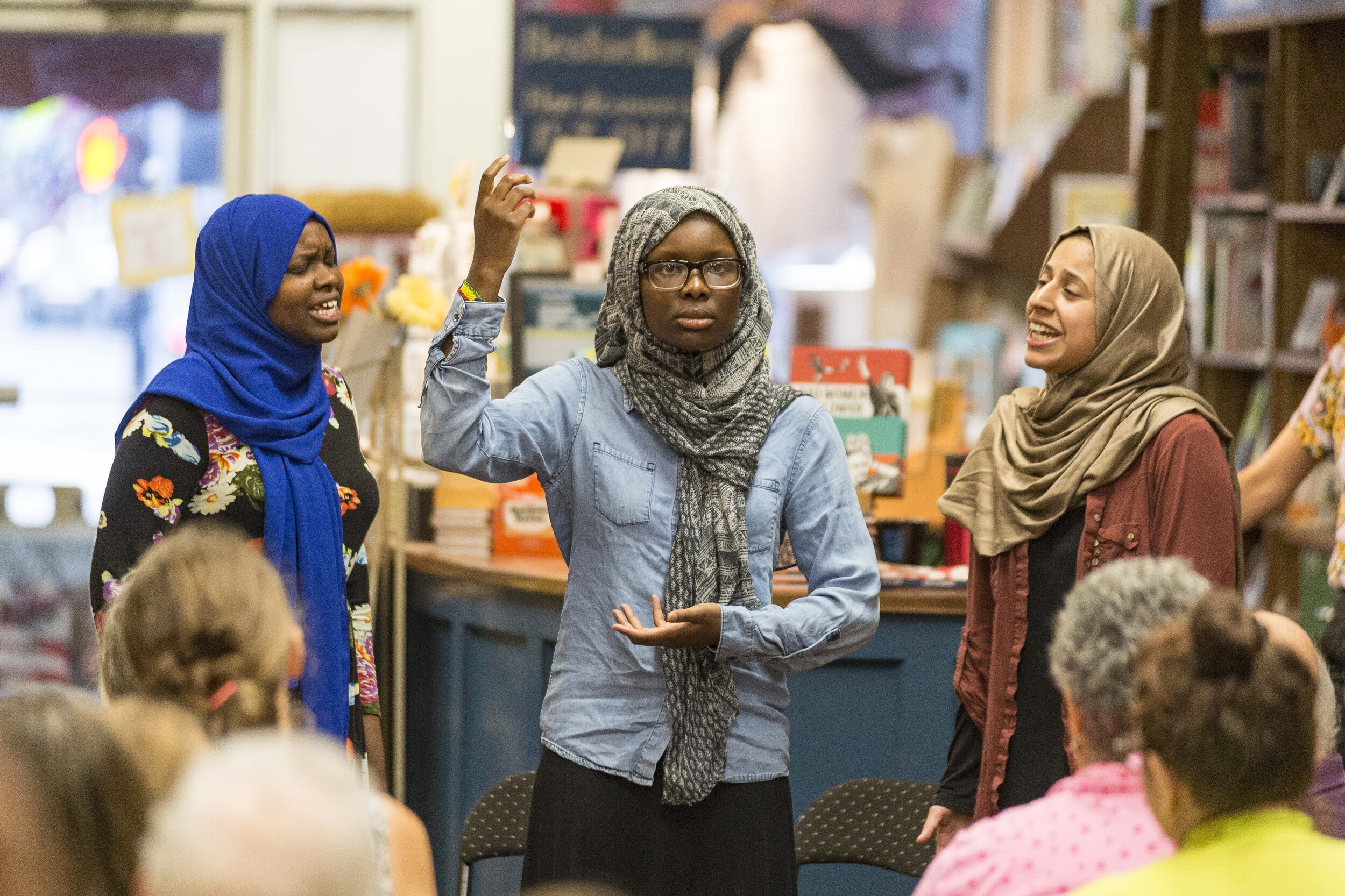  Haha Adam, Balkisa Omar, and Lena Ginawi of Muslim Girls for Change perform "Wake Up, America," a slam poetry piece about the Syrian Refugee crisis, during an event at Bear Pond Books in Montpelier, VT on Tuesday, August 7th 2018.     