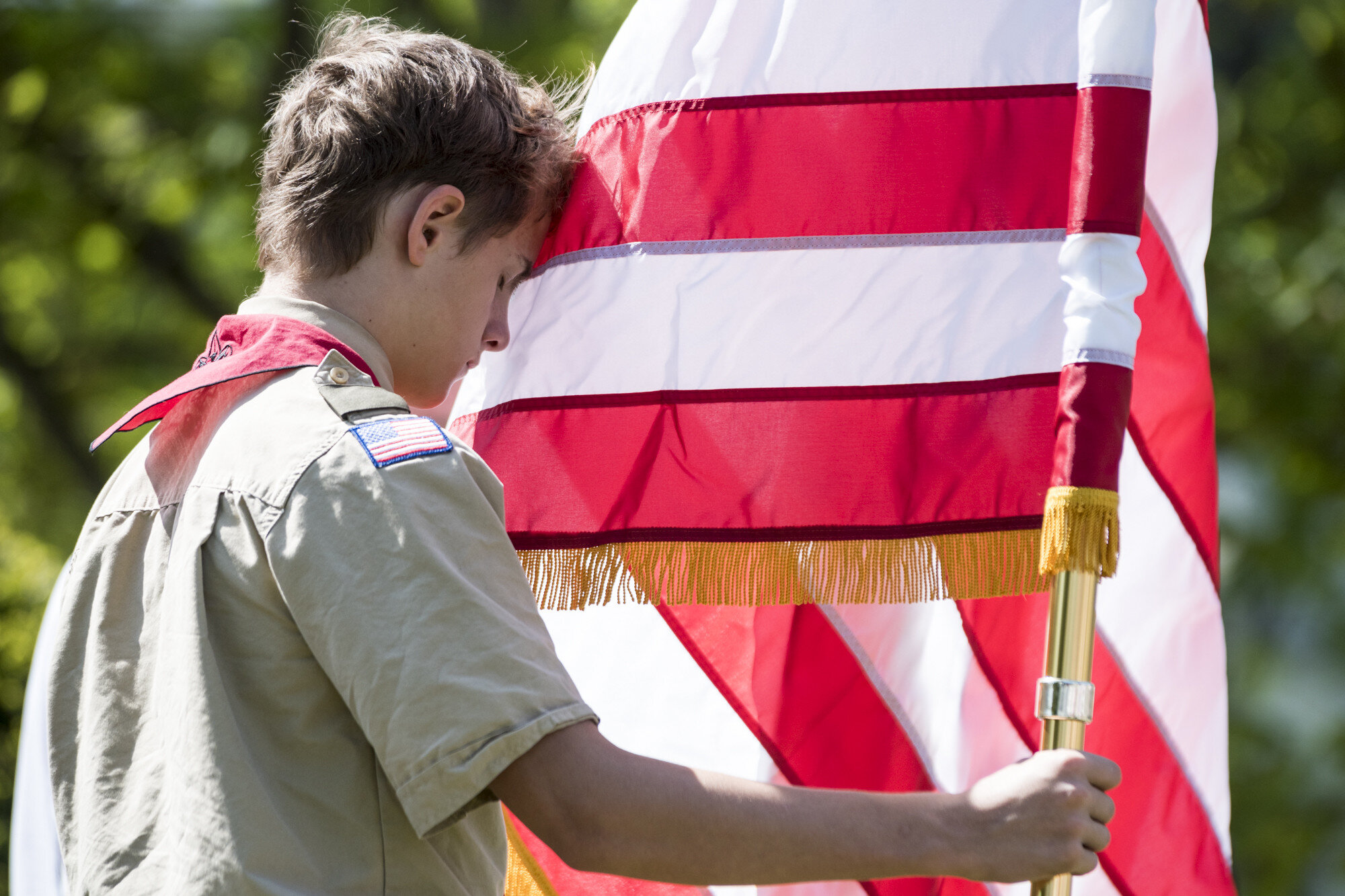  Elijah Myer of Boy Scout Troop 759 holds steady a windy American flag during a moment of remembrance while serving as the color guard for a Memorial Day Commemoration in Northfield, VT on Monday, May 27th 2019. 