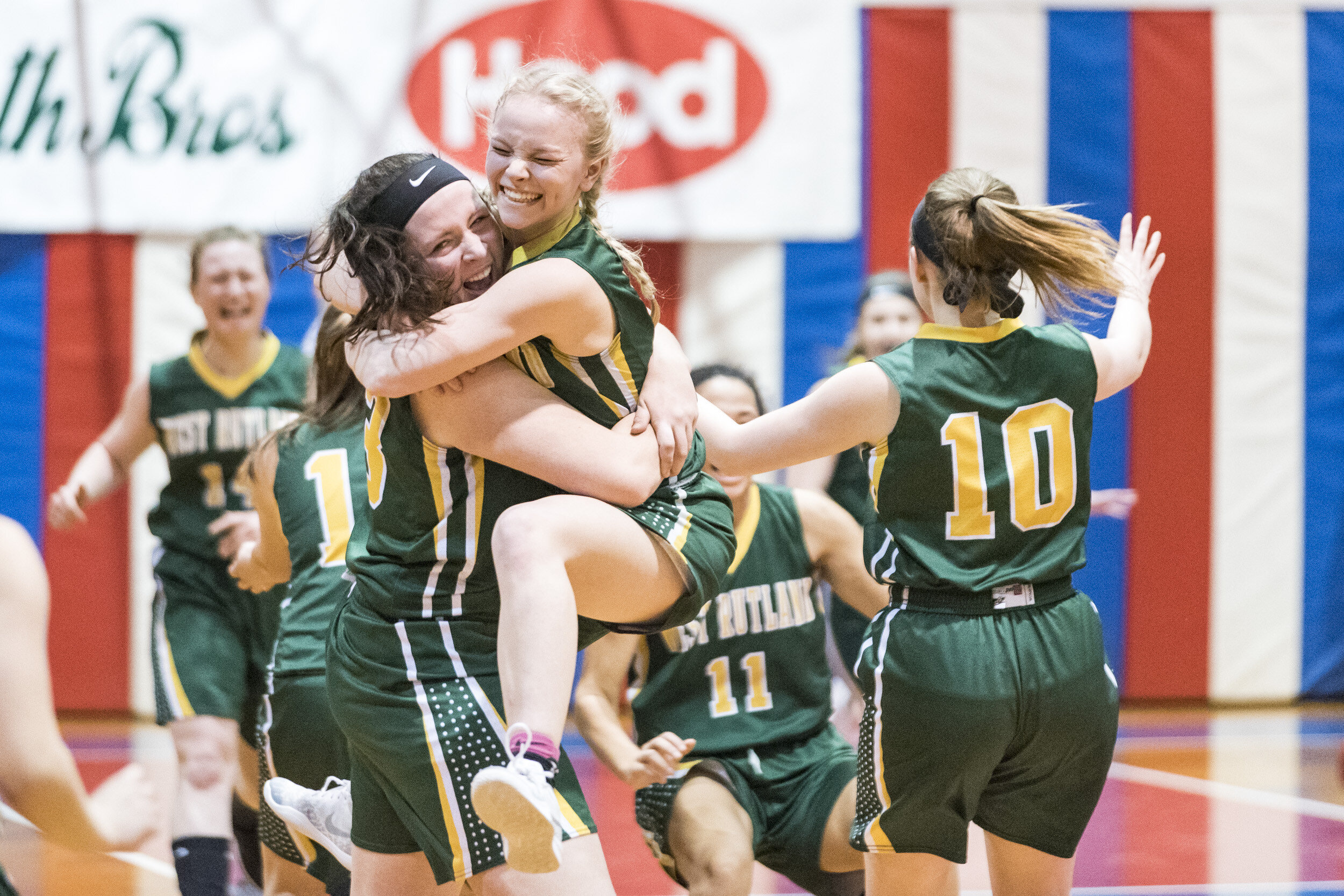  West Rutland's Kiana Grabowski jumps into the arms of teammate Elizabeth Bailey as the Golden Horde celebrates their Division IV championship win over Blue Mountain Union at the Barre Auditorium on Saturday, March 9th 2019 in Barre, VT. 