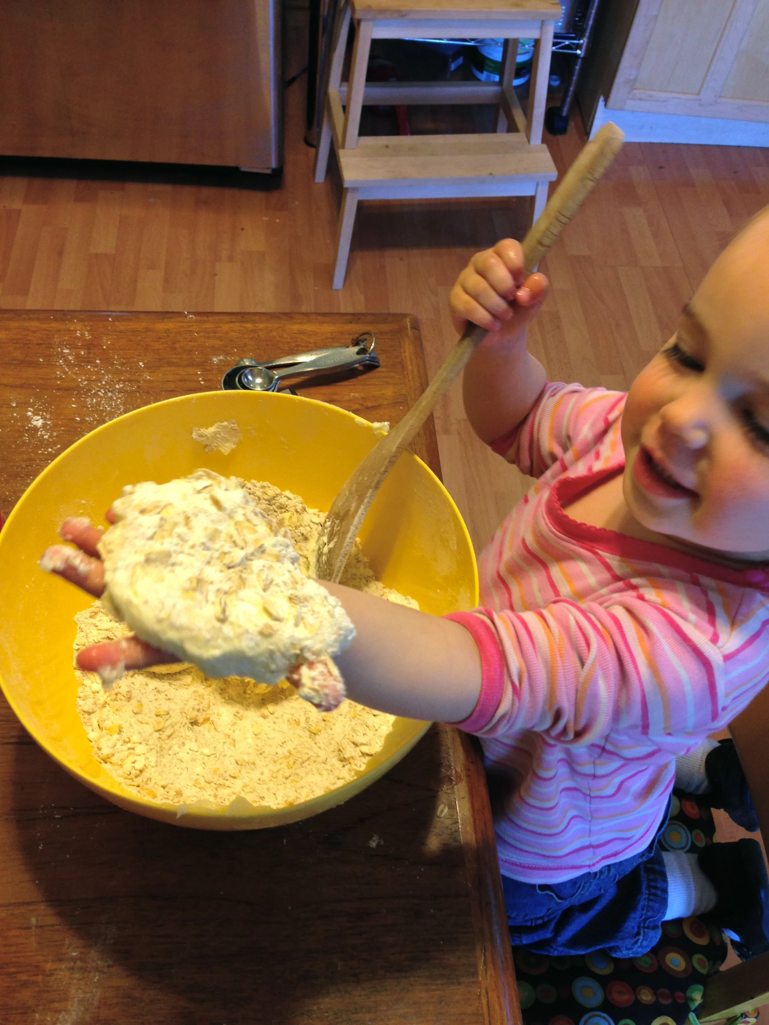 Mix the butter into the oat mixture. Try using a spoon, a spatula, press it with your fingers, squeeze it with your fists, and any other technique you and your little one can think of. Greasey powdery oat-y fingers for everyone!