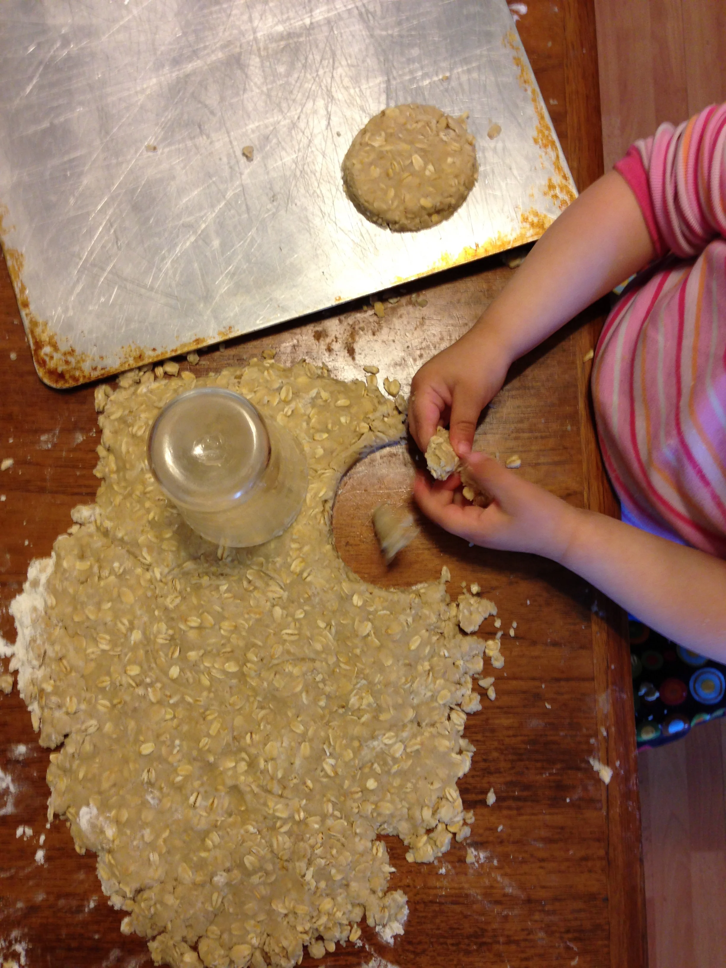I help get the sticky circles off the table and onto the pan. 