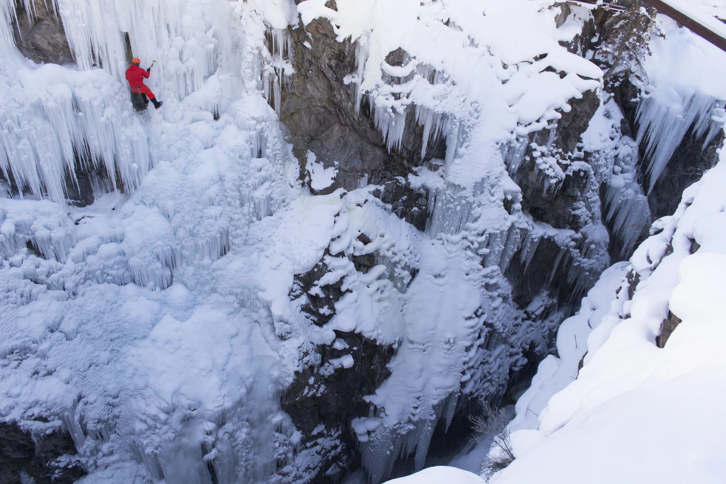 An experienced ice climber hovers over the icy gorge at the Ouray Ice Park.