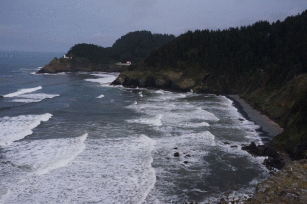 Waves along the Oregon coast and Heceta Lighthouse in background