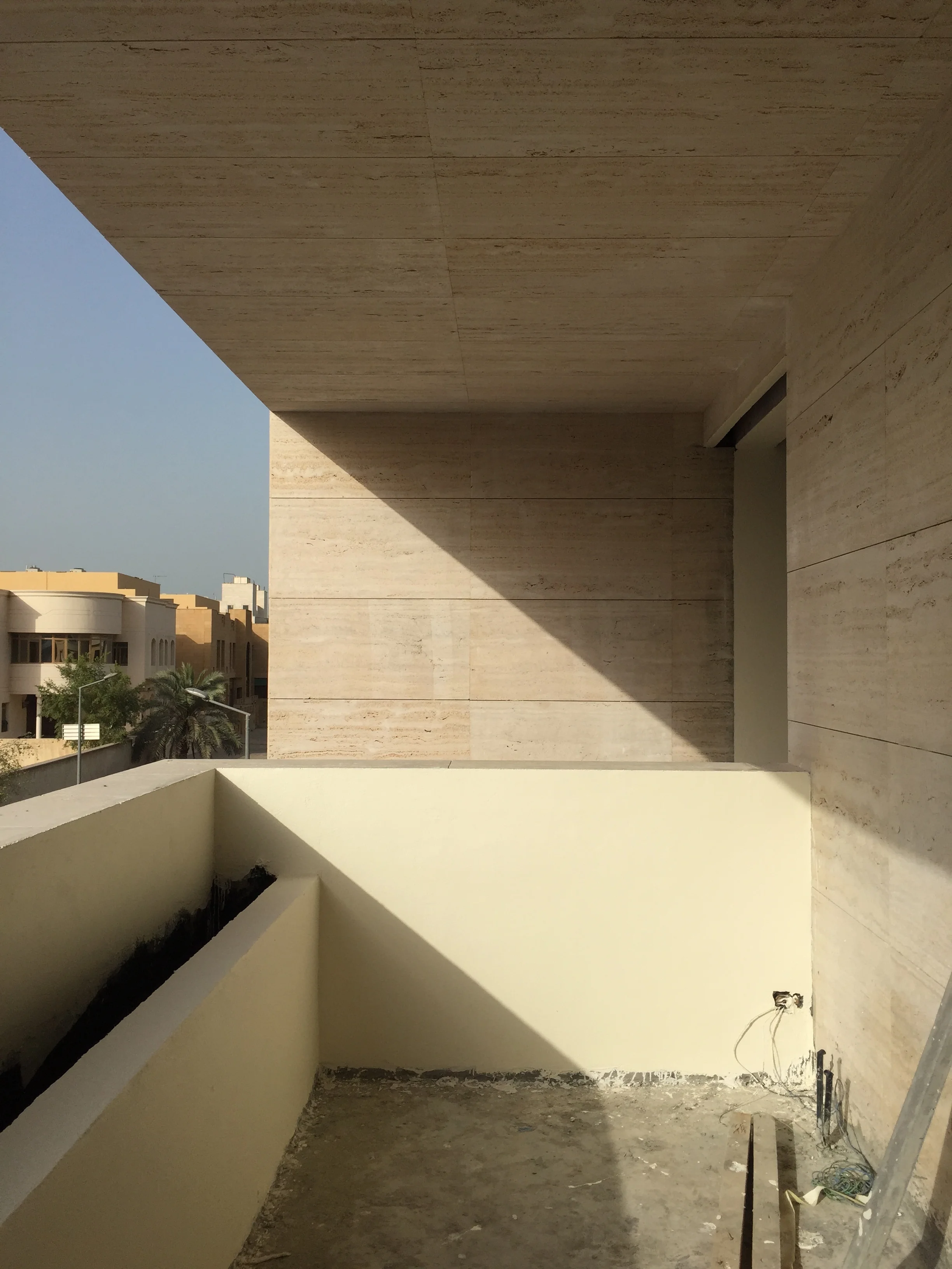 A shaded terrace facing the service street, and overlooking the main entrance of the villa