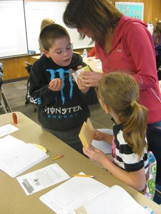 Students building their sound reducing wall with their teacher.