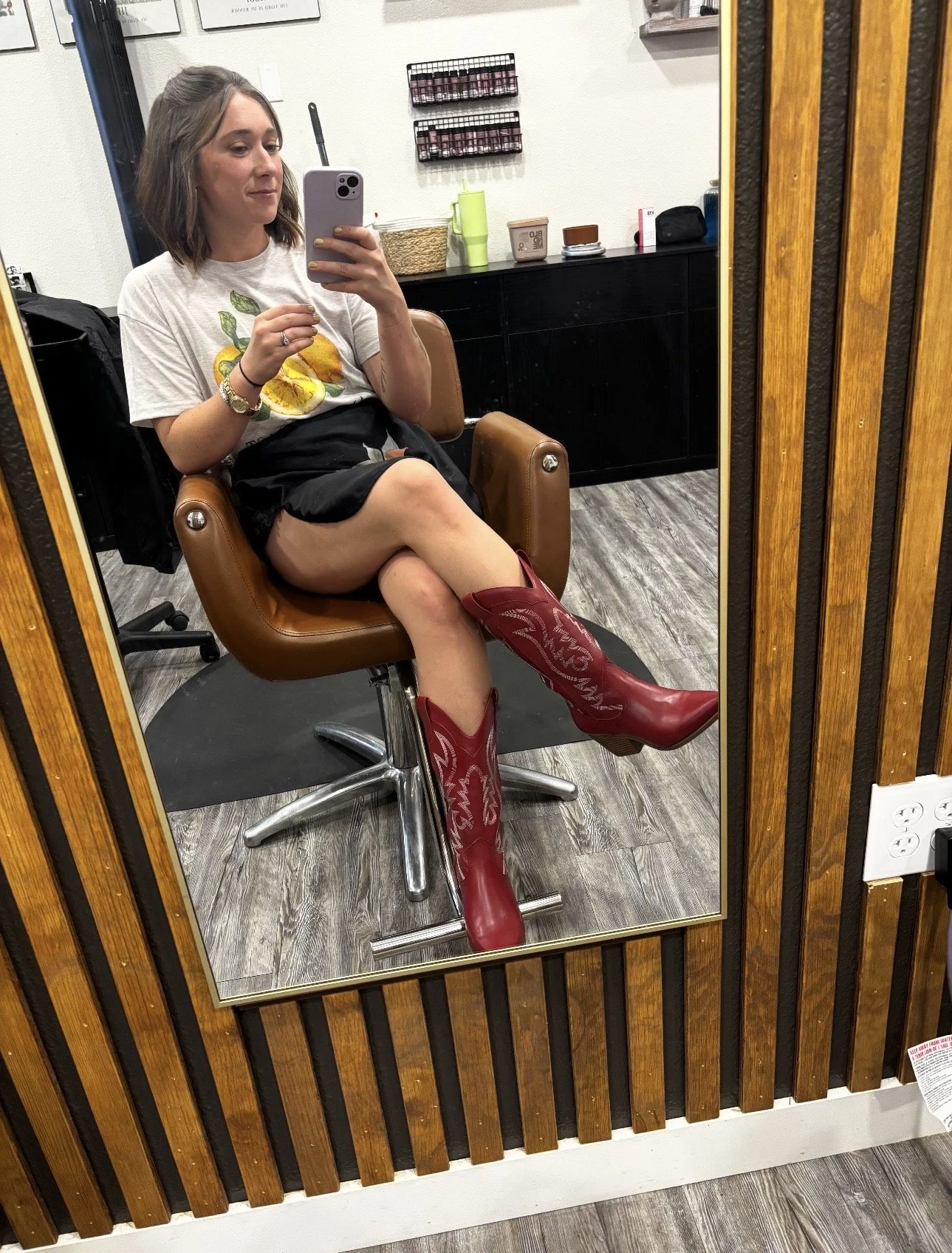 Interior of a modern hair salon with two styling chairs, mirrors, and wood-paneled walls.