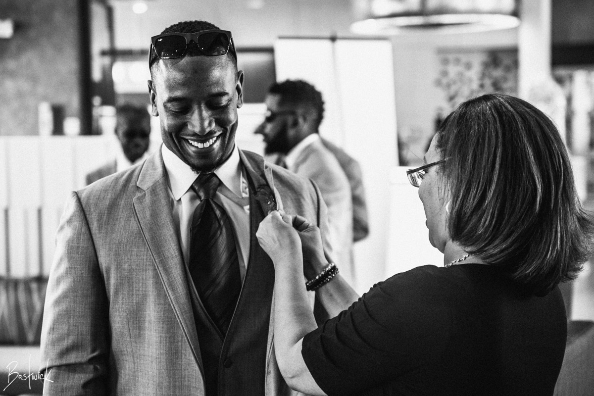 Chief Event Planner Randi Martin pinning the boutonniere on a groomsman. Photo by Daniel Bostwick Photography