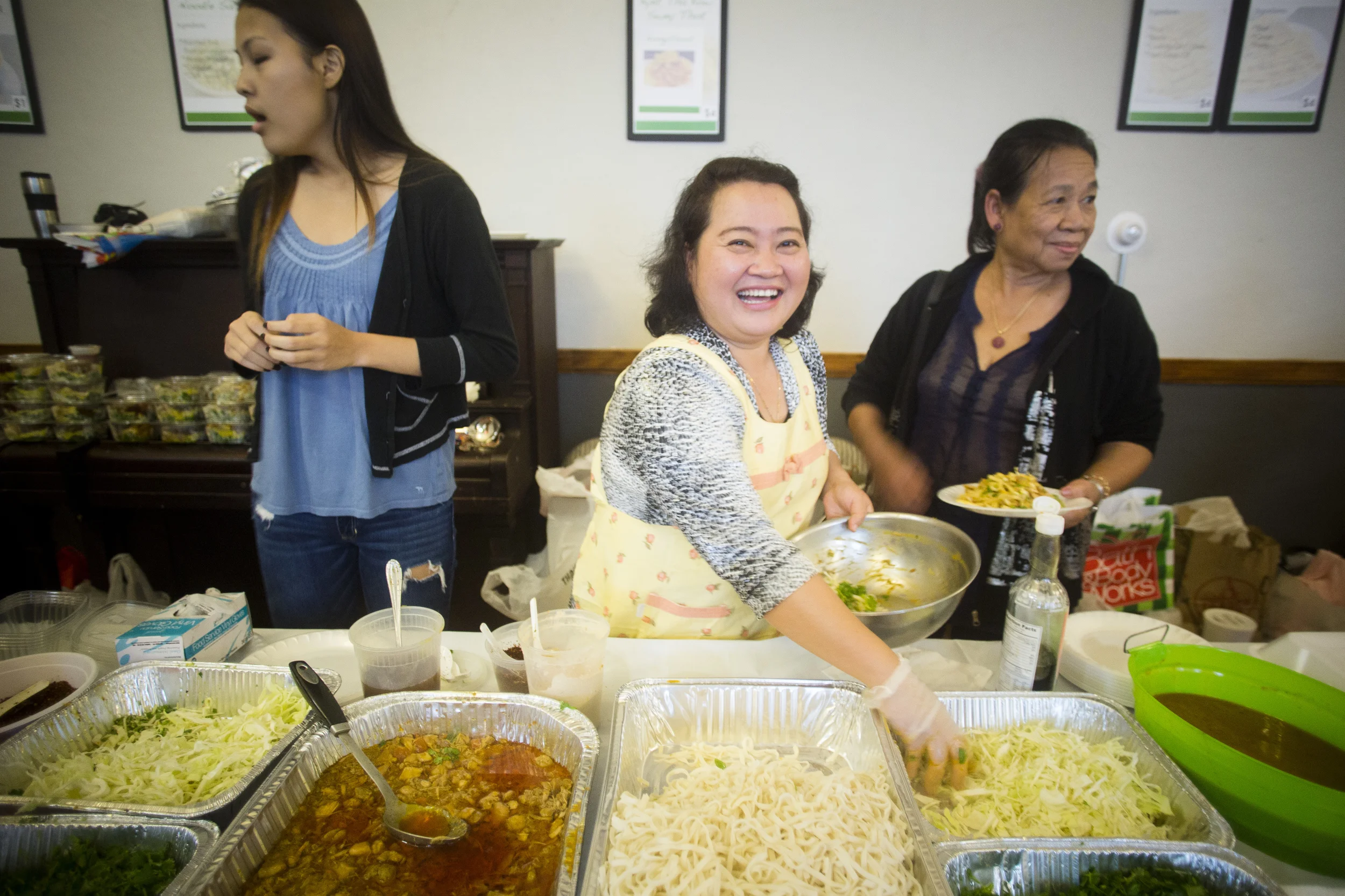 "Come try our food! It's very good!." while busy mixing noodles for the customers. By Ann Wang