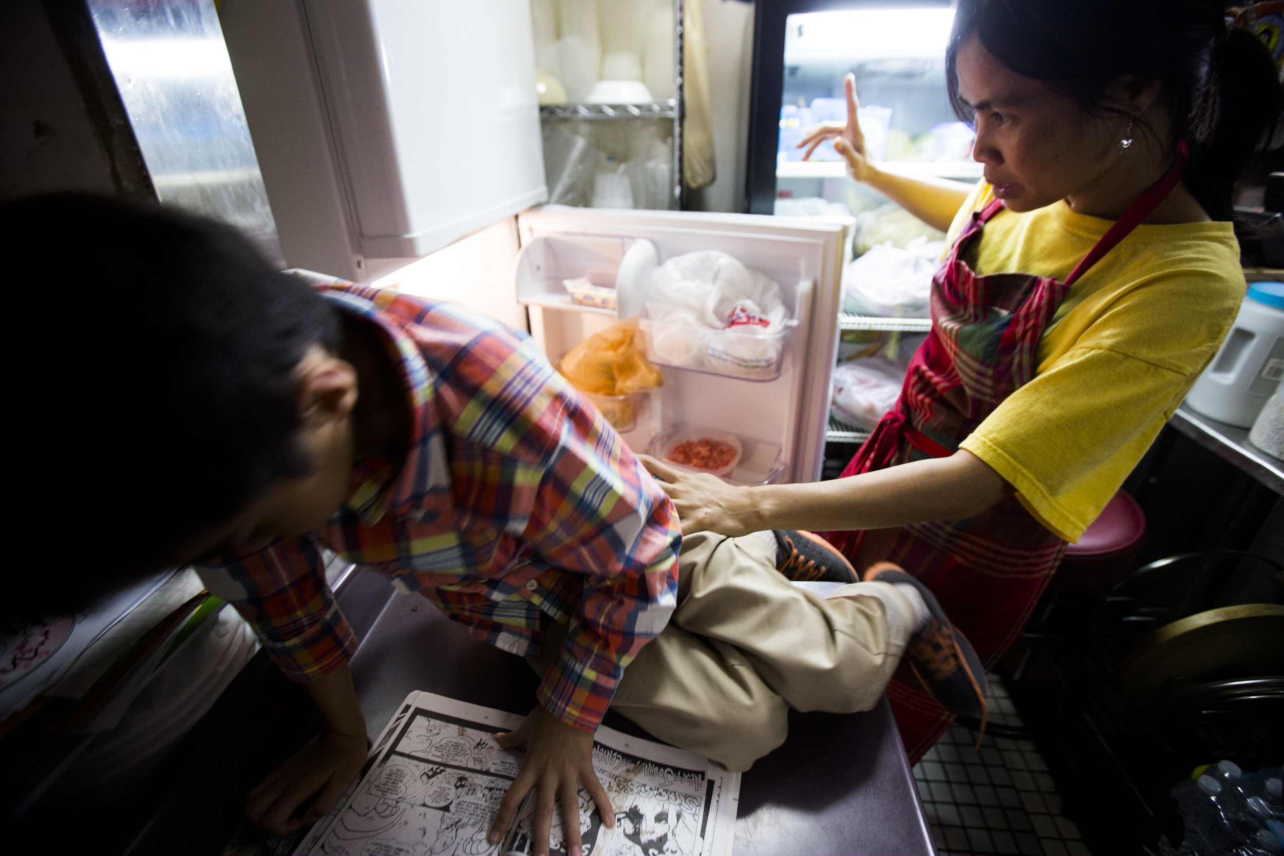  Thawdar Kway (R) collecting food from the fridge while talking to her son, Henry Kway (L). By Ann Wang 