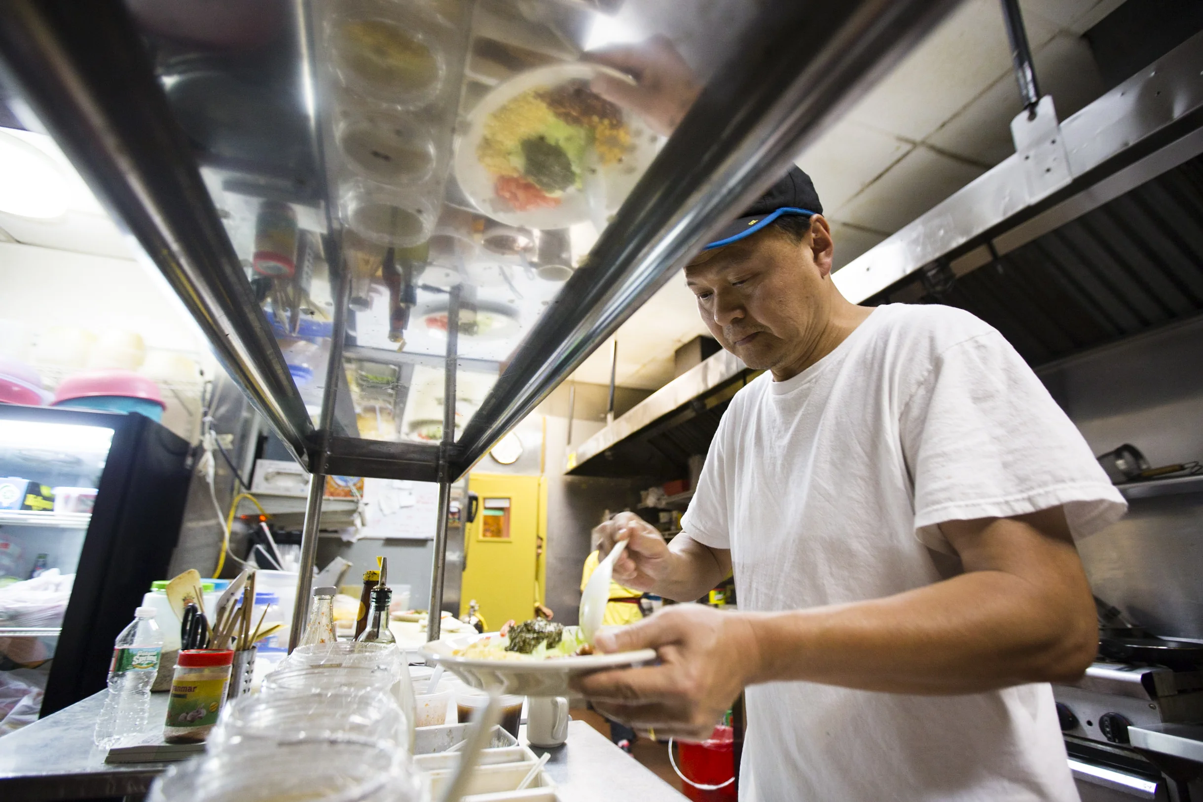  Owner and top chef of Yoma restaurant Sai Kyaw preparing tea salad in the kitchen.
By Ann Wang 