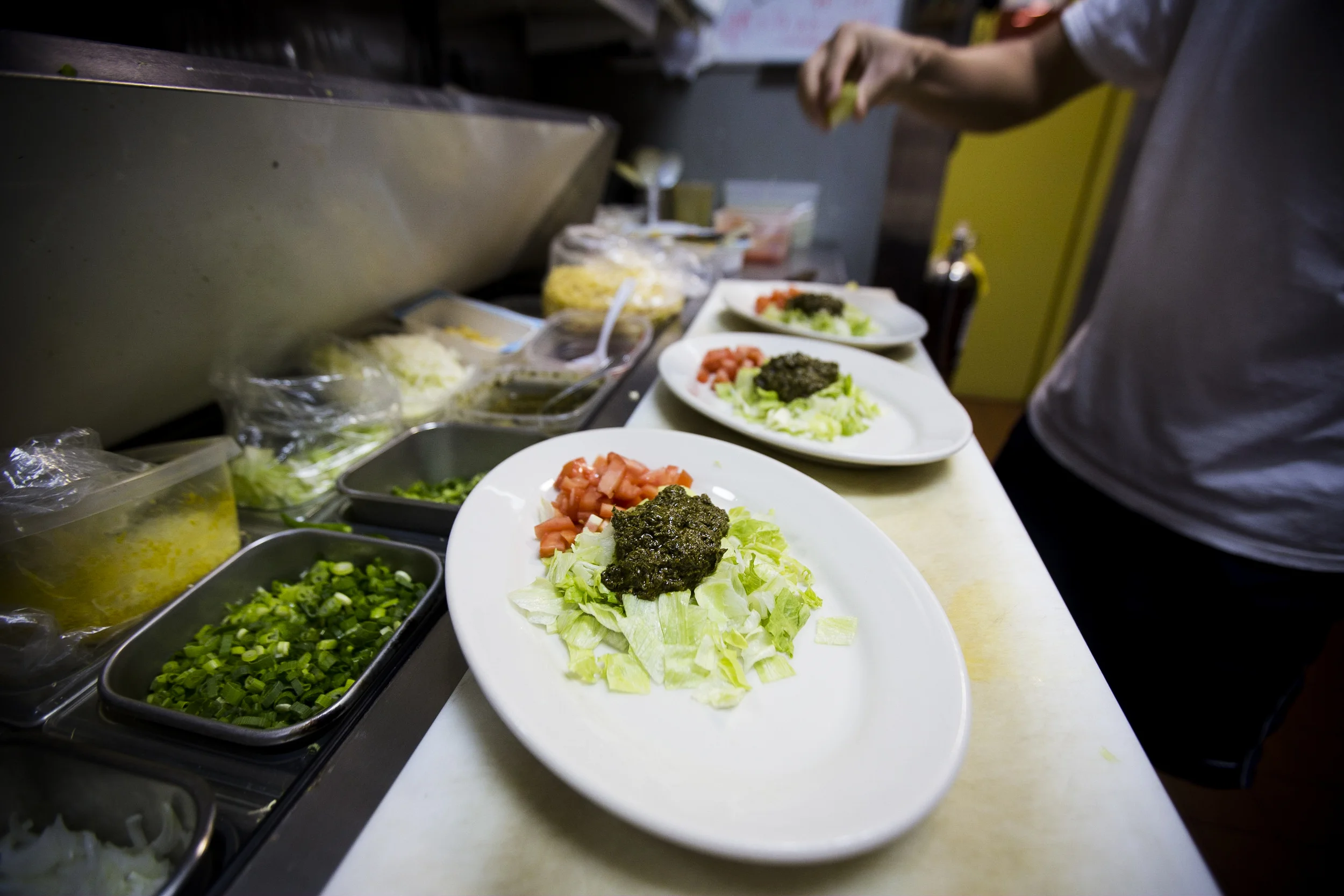  Owner and top chef of Yoma restaurant Sai Kyaw preparing tea salad in the kitchen.
By Ann Wang 