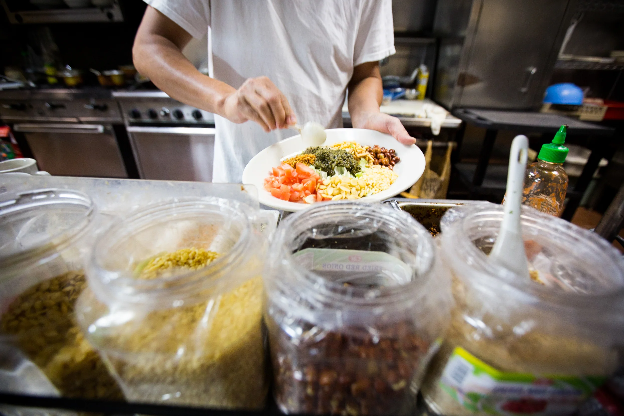 Sai Kyaw, the owner and chef of Yoma restaurant, preparing signature dish the "Tea Salad" in the kitchen of Yoma in Allston, Mass. Photo by Ann Wang