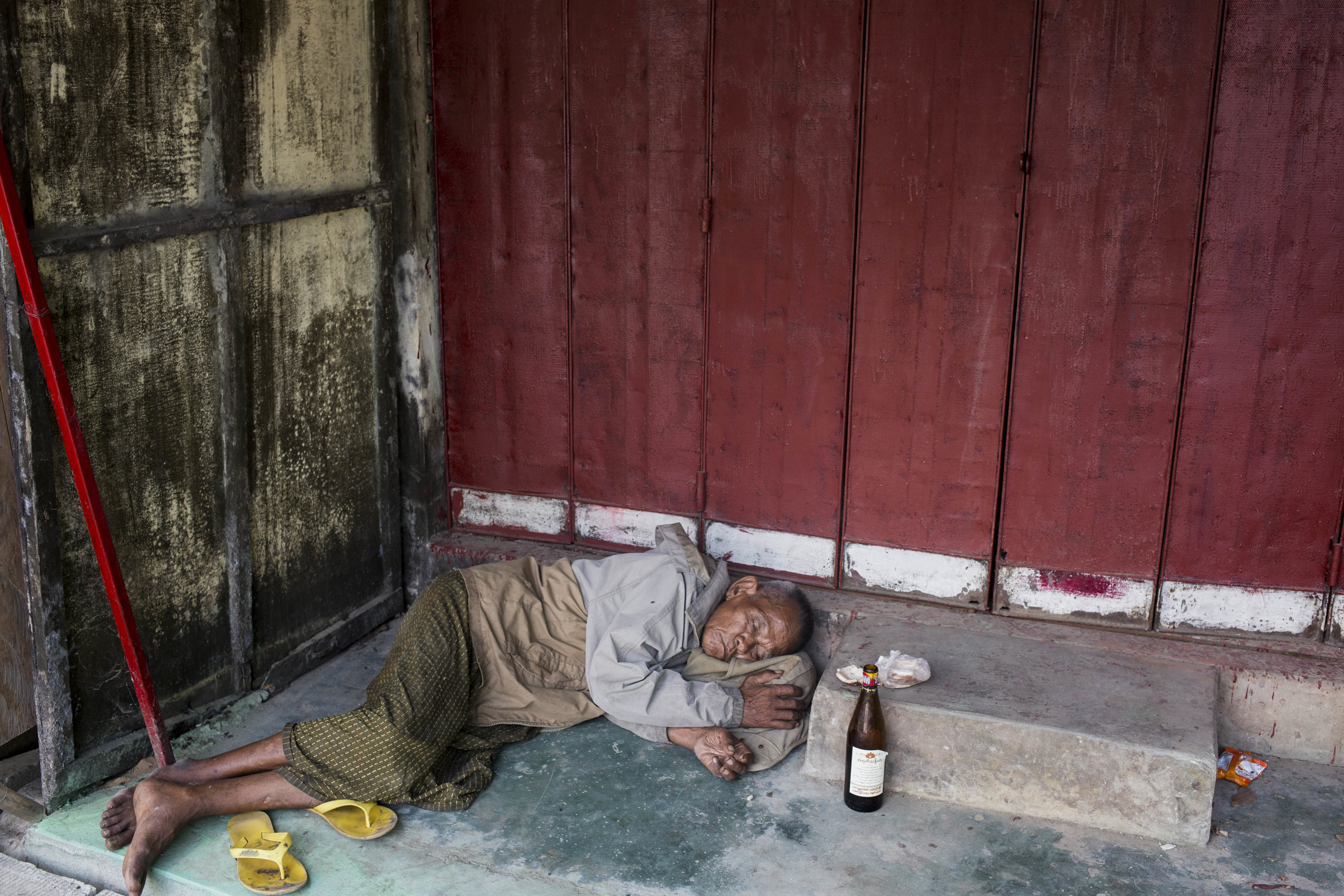  A drunk man is seen in downtown Yangon. The bottle in front of him is rice wine from Myanmar, which contents 40% alcohol and can be purchased under 1000 kyet (1 usd). Photo by Ann Wang 