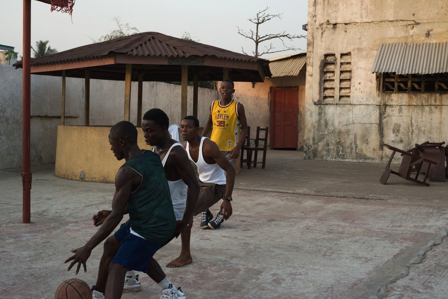  Young men play a pick up game of basketball around dusk on a beachside court outside of Monrovia, Liberia.  