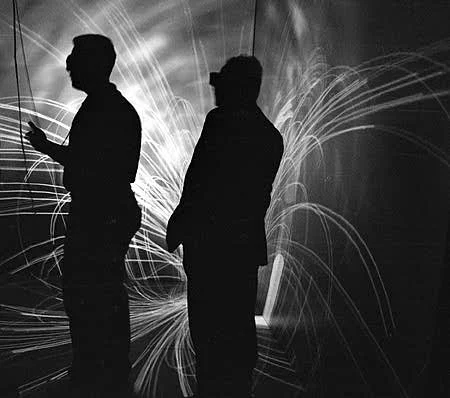 Image/Caption Credit: NASA, 1998 "Magnetic field lines from a coronal mass ejections appear to envelop virtual reality CAVE users. UM aerospace engineering seniors Stuart Feldman and Aaron Jacobovits developed the visualization application, which allows researchers to fly through the information and find particular features."