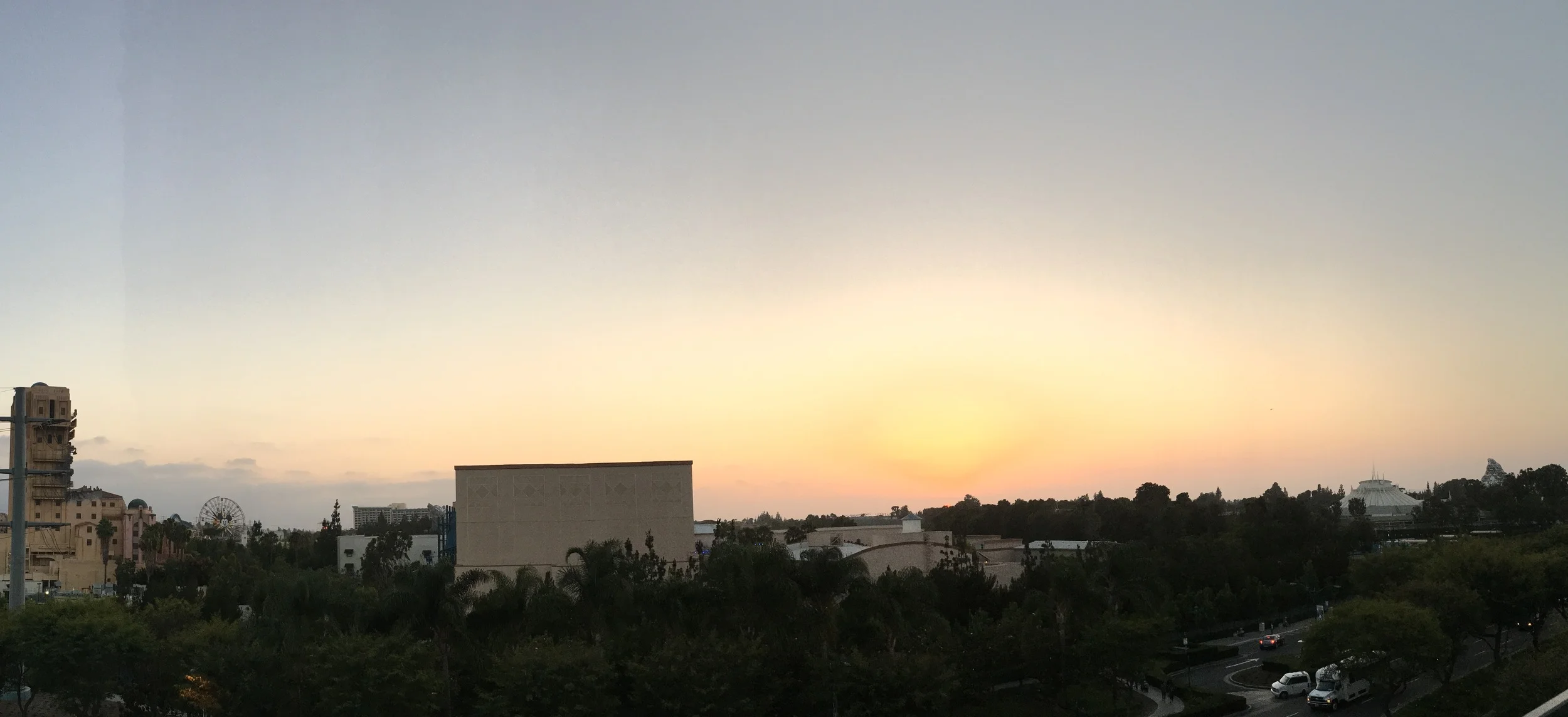 Panoramic view of the sun setting behind Disneyland and Disney California Adventure. Click to expand.