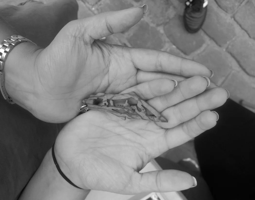  Nadia’s grandparents fled Palestine in 1948 and settled in Jordan. The key chain Nadia always carries with her is a map of what once was Palestine.  Name: Nadia.  What: Key chain with a map of Palestine crafted from olive tree.  09: The imprint of N