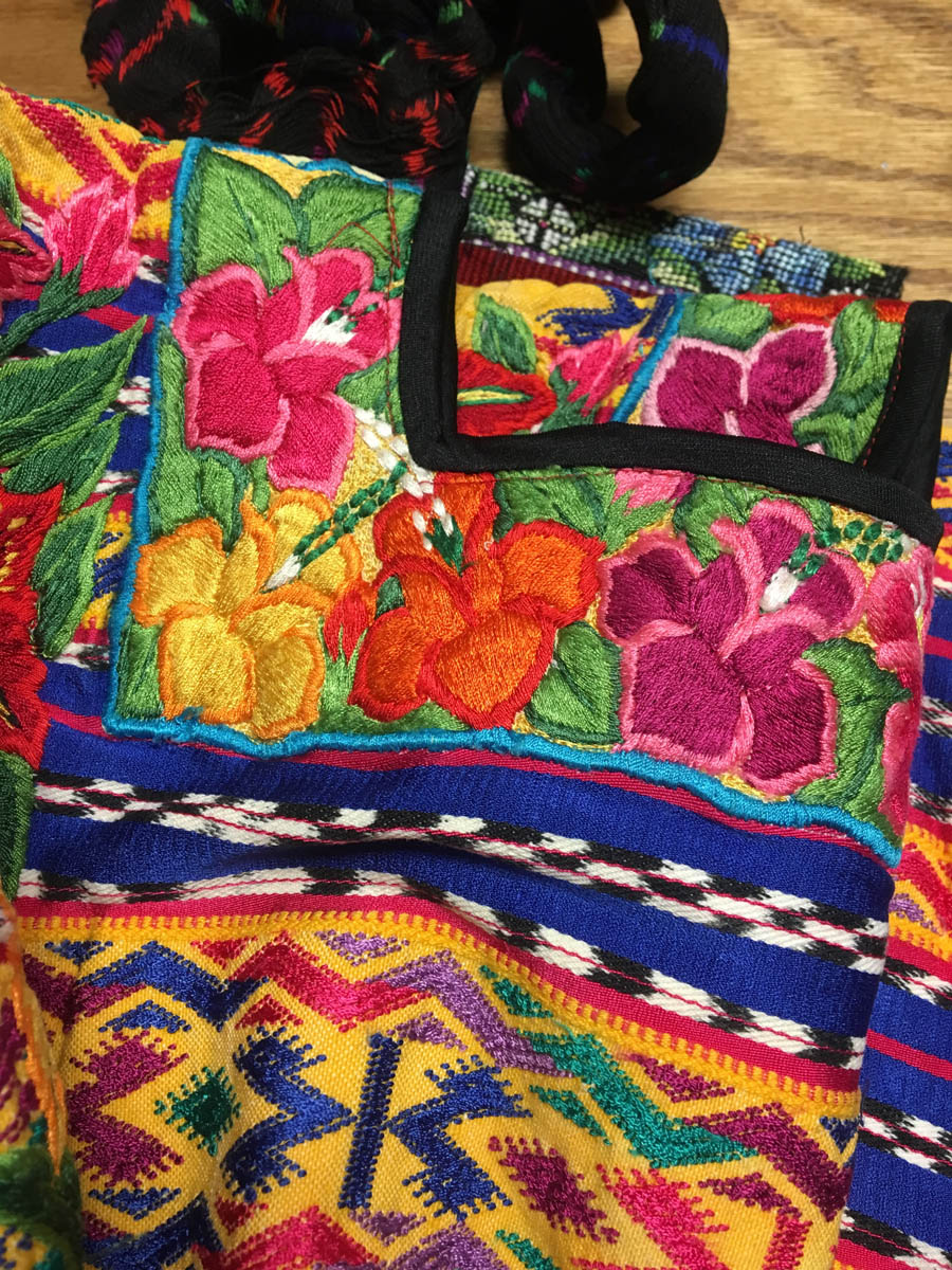 The decoration around the neck is embroidered (perhaps by machine), the rest is woven.