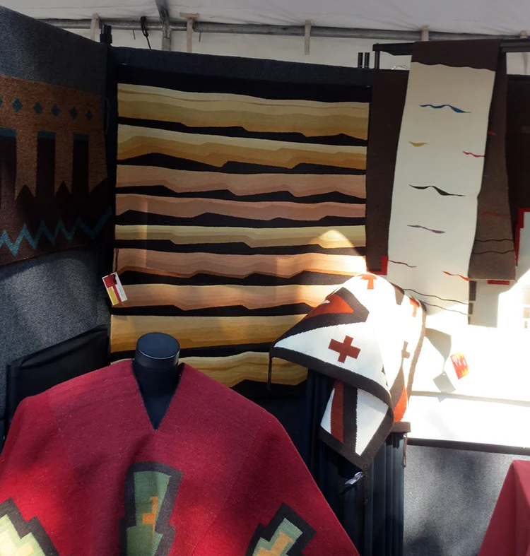Indian Market 2013. DY Begay's weaving in her booth with her two sisters Berdine Begay and Berdina Charley