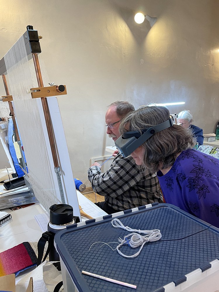 Karen and Jon looking at his large tapestry