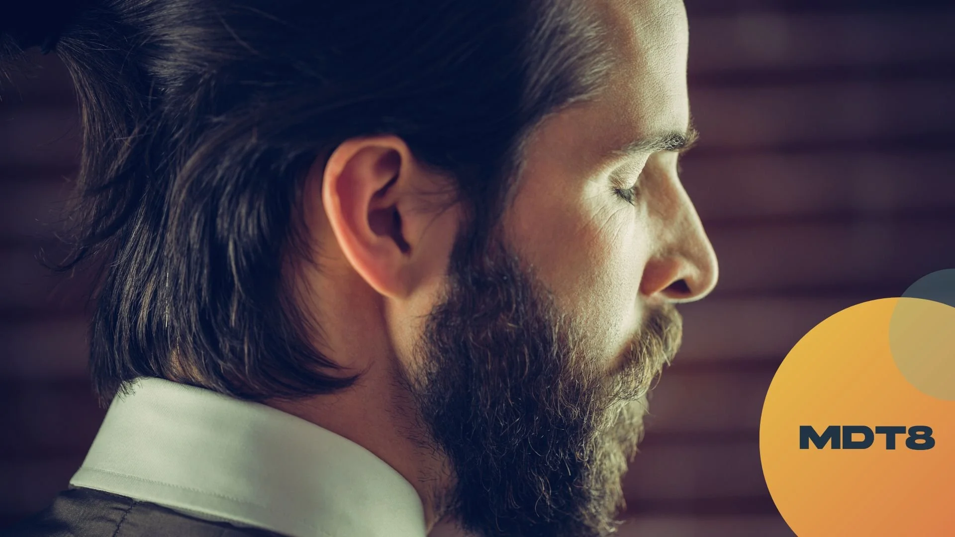 Close-up profile of a man meditating with his eyes closed, with the MDT8 logo.