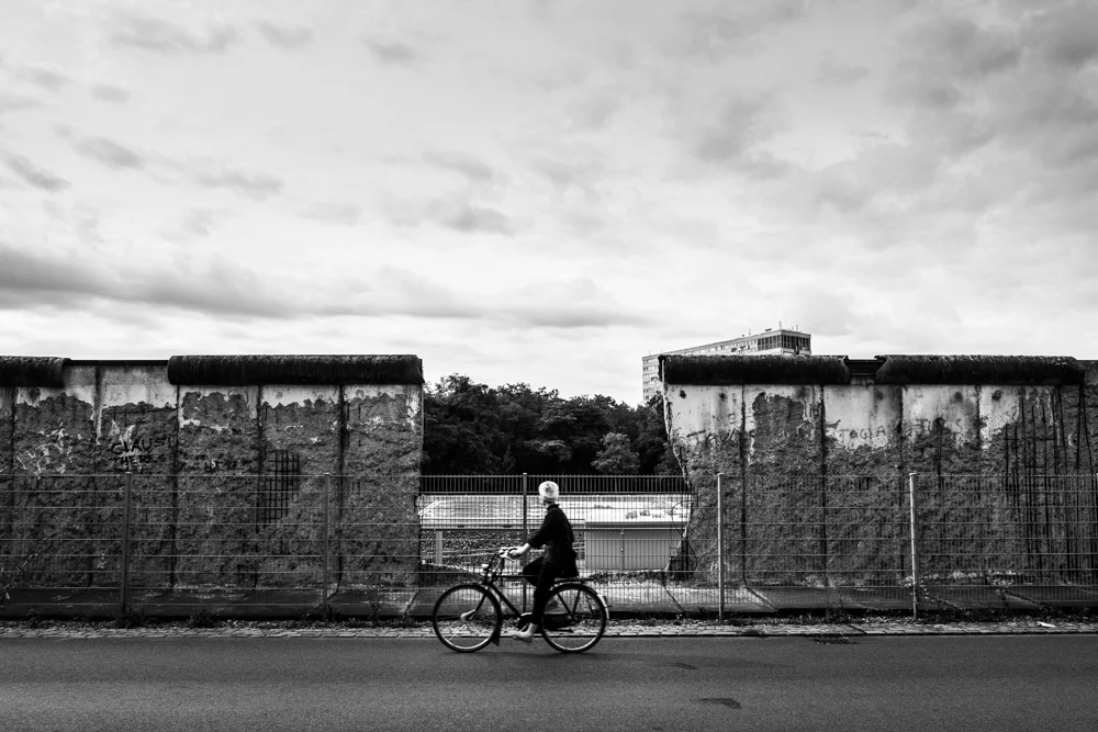 A woman cycles by the Berlin Wall in Germany. 