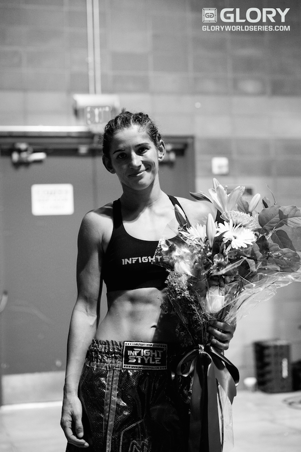 A victorious Tiffany Van Soest backstage with a bouquet and a smile. 