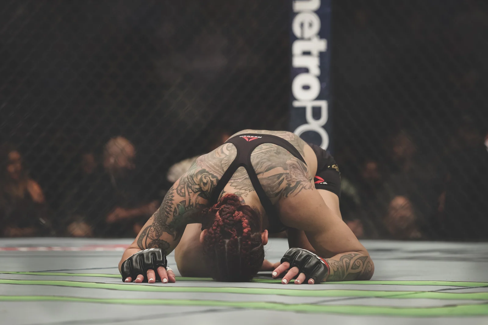 Cris Cyborg kneels in the center of the Octagon after defeating Yana Kunitskaya at UFC 222 in Las Vegas, NV.