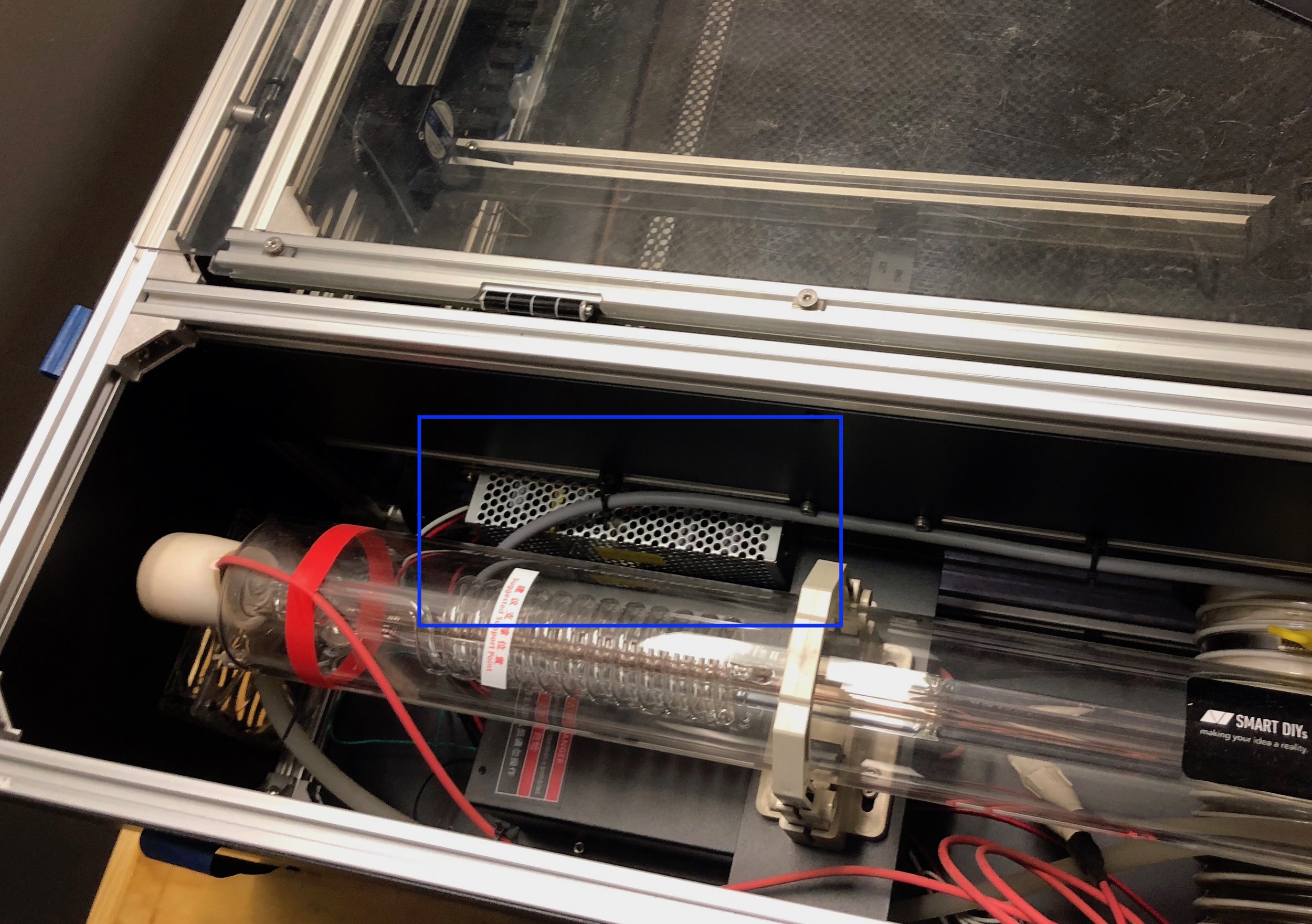 We installed a 24V power supply on the smoked acrylic wall. This would have been much easier to do before the laser tube was installed.