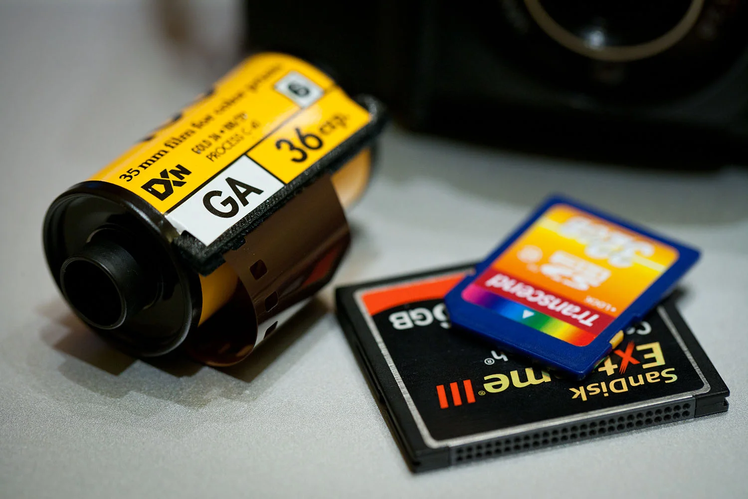 Some photography veterans are still debating wether or not to make the switch to digital, they feel intimidated by the technology and fear to let go of their labs, light tables, and magnifying glasses. Due to the dificullty in finding good stocks of film, they're probably feeling down at the moment.. Well, don't be.
I had the privilege to work with one of these veterans in a photography project a while back. He's still using film, while I'm using digital technology exclusively. Let me give you glimpses of our workflow.. Note: both of us are based in Riyadh, while our photography scopes were in other cities.
1) Planning for the outdoor photography sessions
In the night before, I packed my cameras, charged the batteries, and checked on my memory cards. I also made sure my laptop is charged, and packed the USB powered hard disk. My also bought a DC to AC converter (around $50), this will give me a supply of 110V-AC in my minivan in case I need it for any of the chargers.
My friend had imported 10,000 rolls of film for this project and stored them refrigerated. He used to take a load for every session.
On location, I used to verify the captured images to make sure all the client's required work was covered.. My friend couldn't.
2) Back at the hotel
On my return, I download the images from the memory cards onto the laptop's hard disk & categorize them. Then, back them up on the external disk, and make optical backups (CD or DVD). Later, I start post processing the photos using Adobe Photoshop and email the contact sheets to the client to show the work done today.
My friend packed all the used rolls in special containers, and shipped them to his office for development and feedback they were OK and it's good to move to the next location. Otherwise, he'll go back to the same location and redo the shoot.
3) At the client's review session
I had previously emailed the contact sheets to the client, so he had an idea of what's covered. However, in the review session, I would make a slideshow on my laptop screen or on the projector when we have more people attending.
My friend kept a light table with the client, and brought his slides & magnifying lenses for the client to see. Chosen ones would be put up the slides projector for a better view.
4) It's delivery time, the client required them on digital media.
All my data was already digital, categorized, and processed; The delivery was done in 48 hours.
My friend bought a slides scanner to digitize the approved work, categorize it, and perform the post processing; his delivery was done 4 weeks later.
To summarize the benefits
Your photography skill is the same in both film and digital cameras. The only difference is you can change the ISO instantly, and don't have to use a different roll of film.
Instant ratification of your photos on location.
You can make as many backups as you want.
No films, no labs, no chemicals, no fumes, no expiration dates.
Studio work is even better, cameras can be tethered to your computer, or get transferred wirelessly to your computer.
The time savings are simply remarkable.
