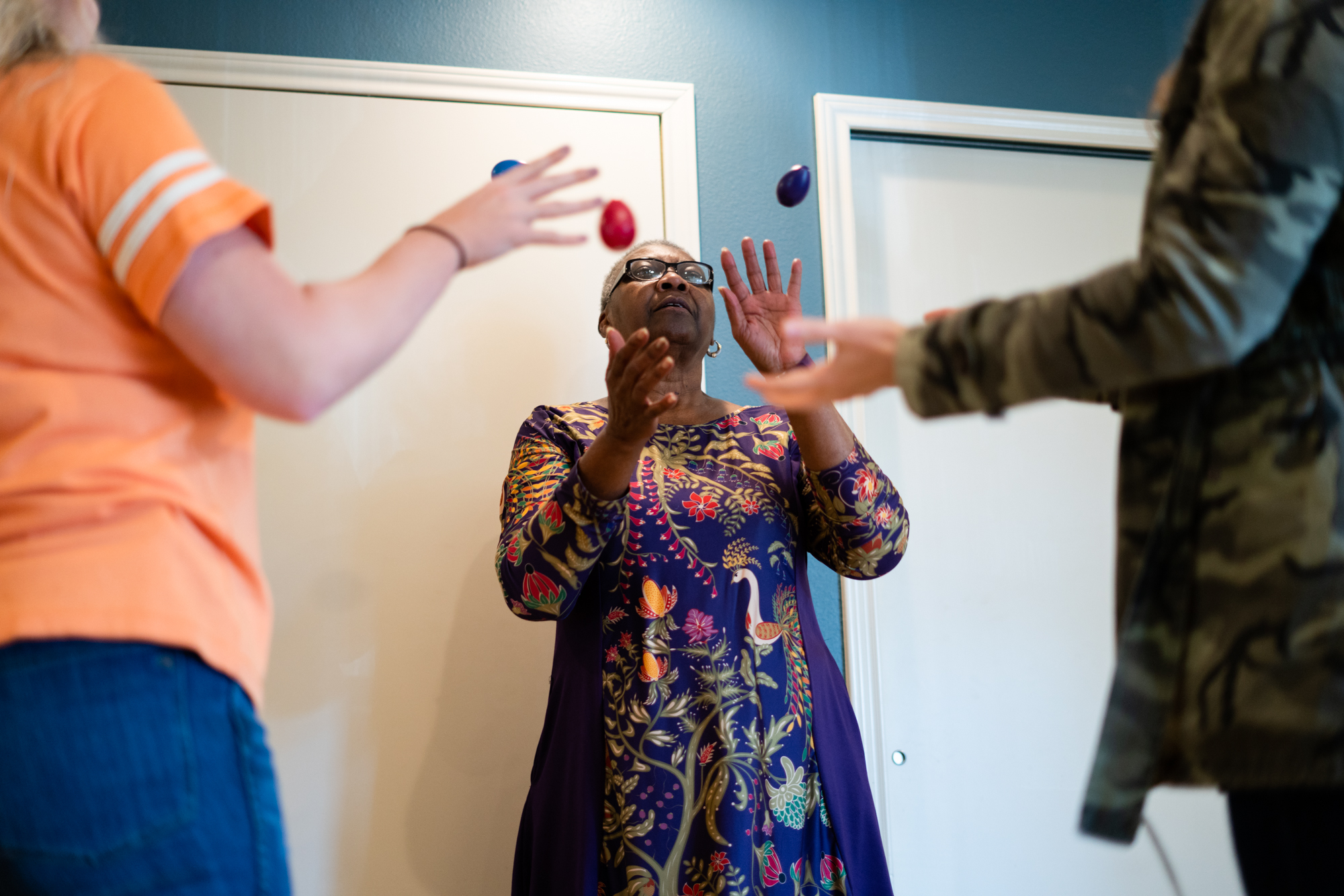 Davis practices an egg toss exercise with two therapists. Hand-eye coordination exercises are routine in her therapy sessions.