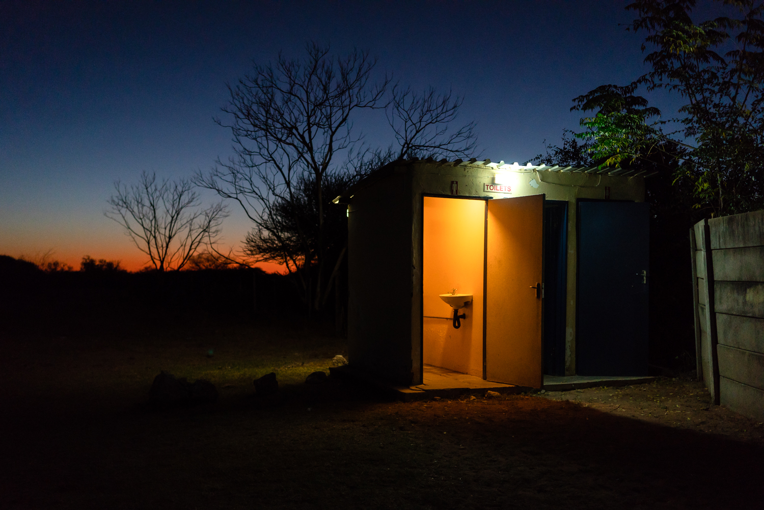 Toilets outside of the only bar in D’kar as the sun sets.