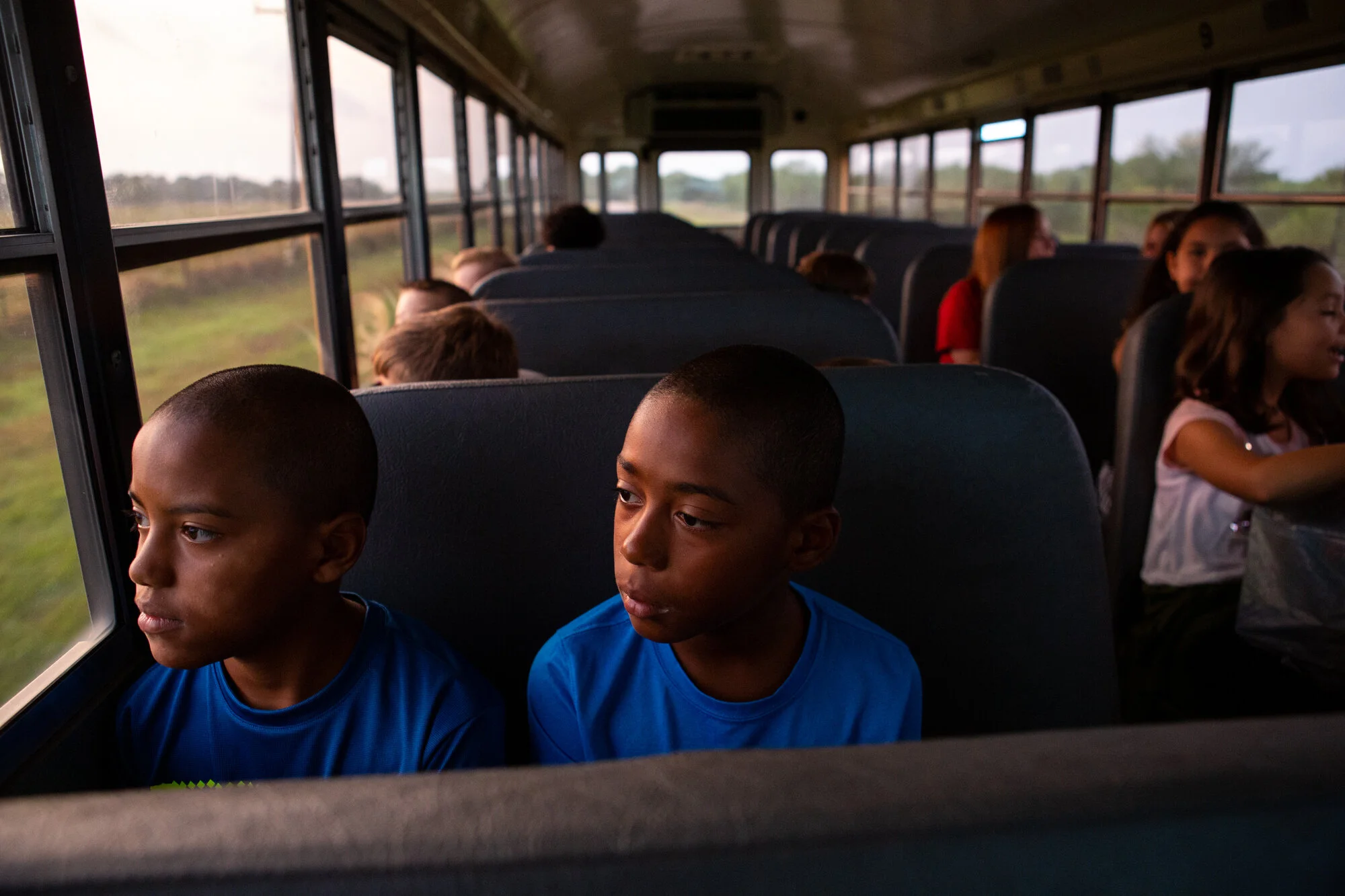  Twin brothers Xavier and Isaiah Baladez look out the window along their bus route to school in Victoria on Aug. 15, 2019.  