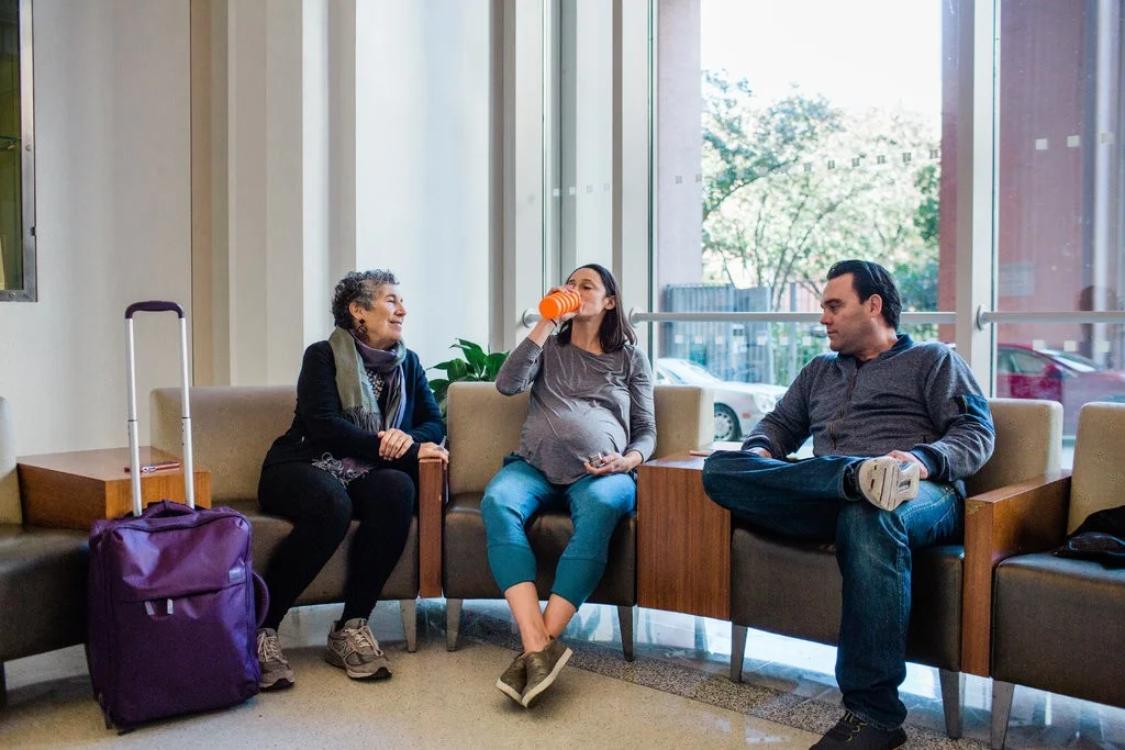 From left, Jane Hirschmann, a doula, sits with Lauren Alzamora and her husband, Cartney Curnuck, in the lobby of Mt. Sinai West, which is scheduled to close its birthing center at the end of the year.CreditGabriela Bhaskar for The New York Times