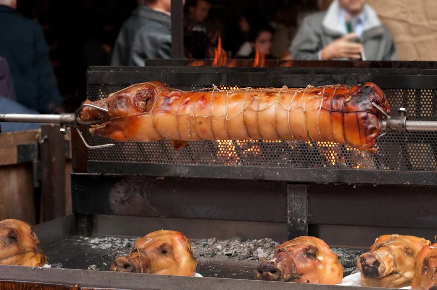 Porchetta roasting over an open fire.