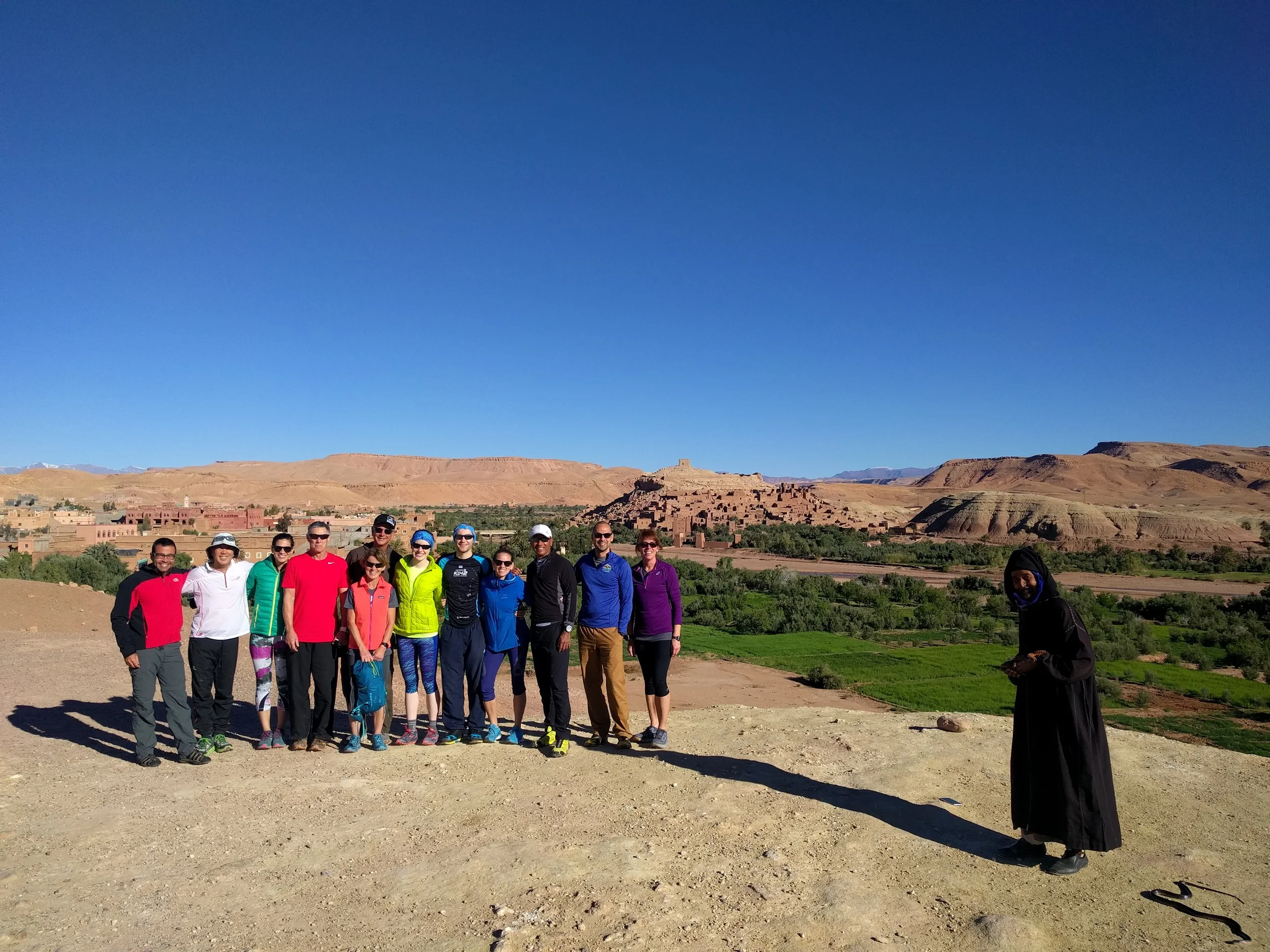 Our Endurance Adventure group in front of Ait Ben Haddou and lush green fields. Local snake charmer approves.