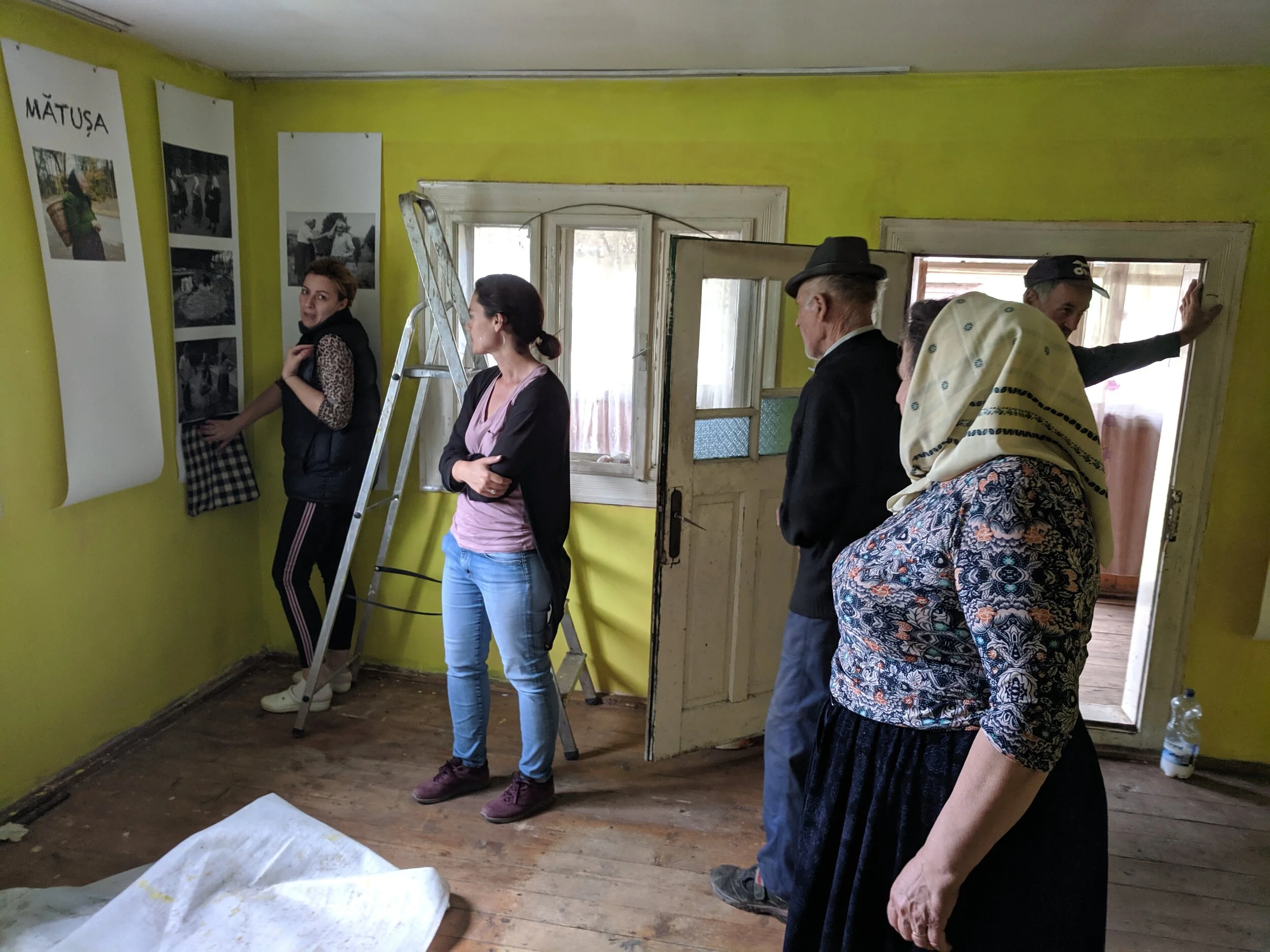 Ileana, Matusa’s great niece, helps layout the installation, while Monica and family chime in.