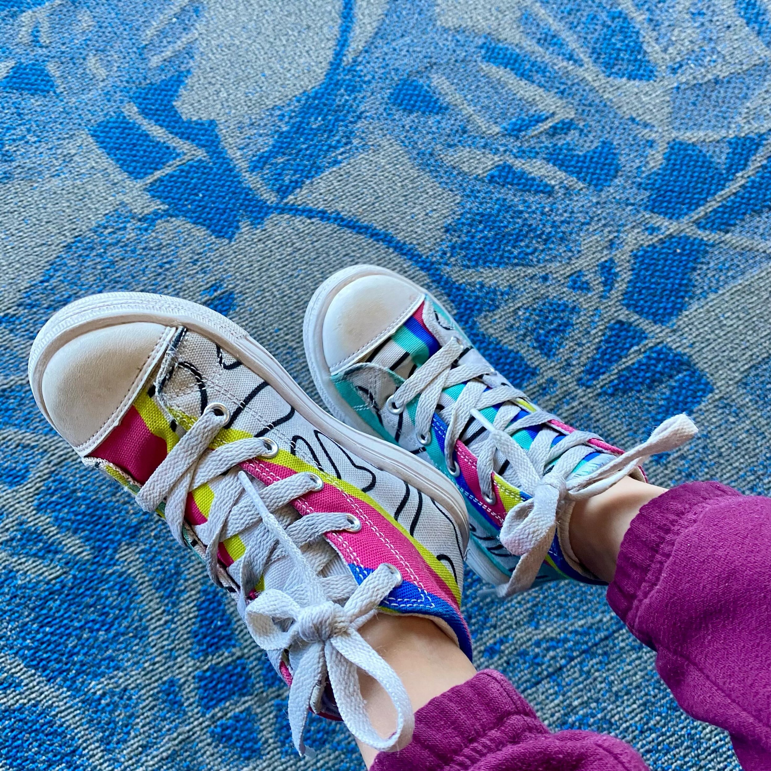 Fly little feet next to me 🩷💛💚🩵💙 You can get my Sunny Flow sneakers for kids, women, and men. Kids sizes start at size 10( around 4 or 5 years most likely) They look good on everyone that wants to live loud and spread smiles 😁 find them in my s