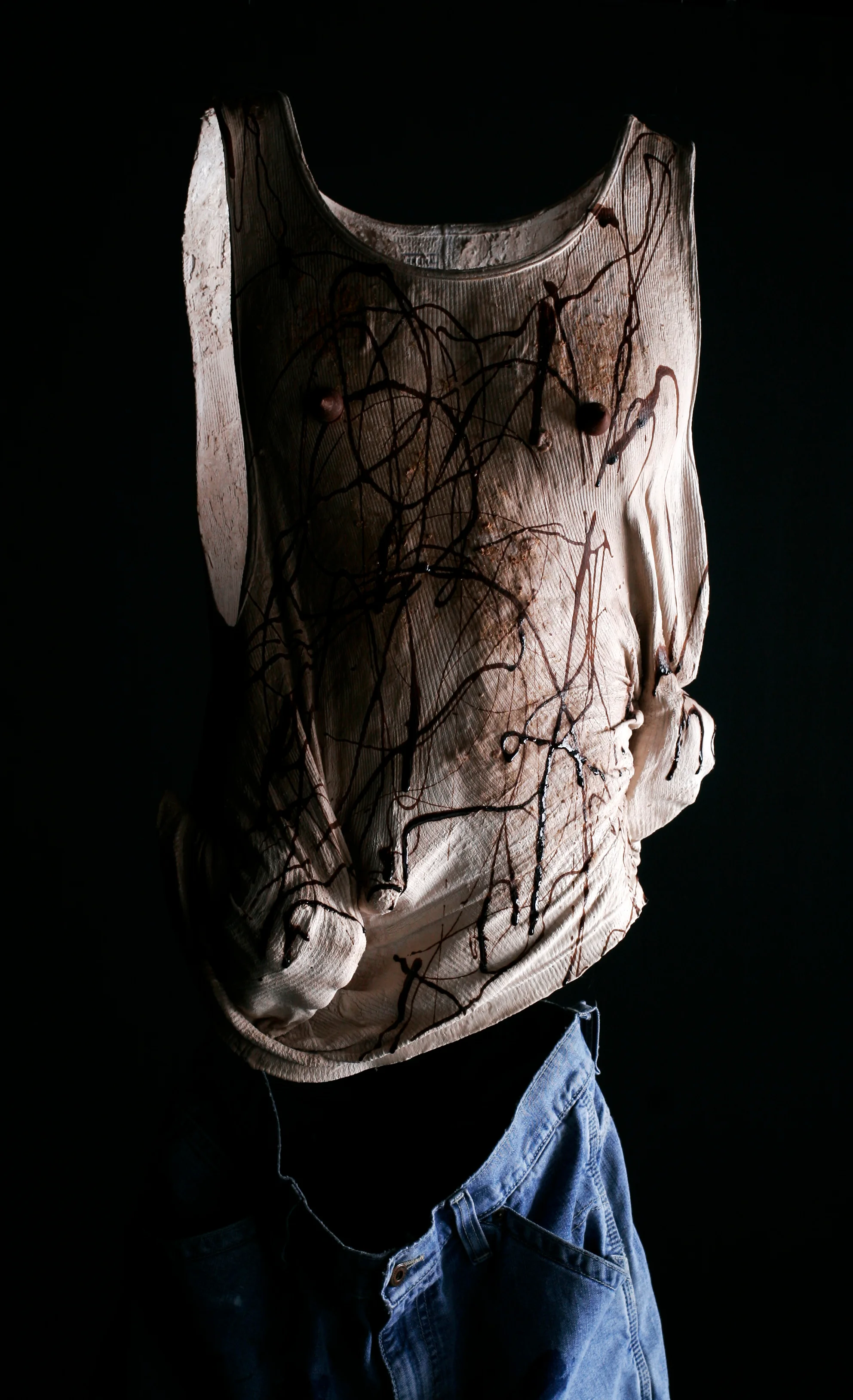 Death By Chocolate 2009 Sculpture: T-shirt, plaster mixed with chocolate and peanut butter, Hershey’s kiss- es, 24”x12”x10”