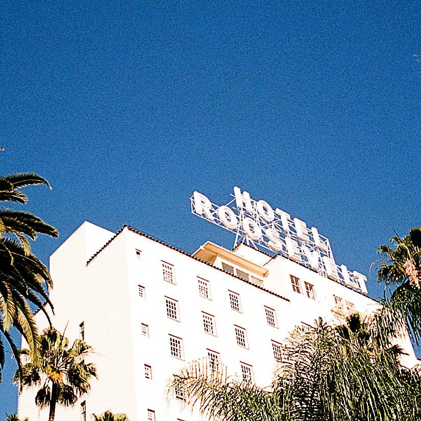 Sign on top of the Roosevelt Hotel building with large white letters spelling 'Roosevelt Hotel' against a clear blue sky.