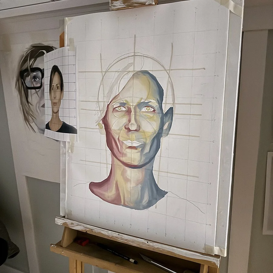 An artist's canvas features a grid with a partially completed portrait of a woman with short hair and striking eyes. A reference photo of the woman is taped to the canvas's side.