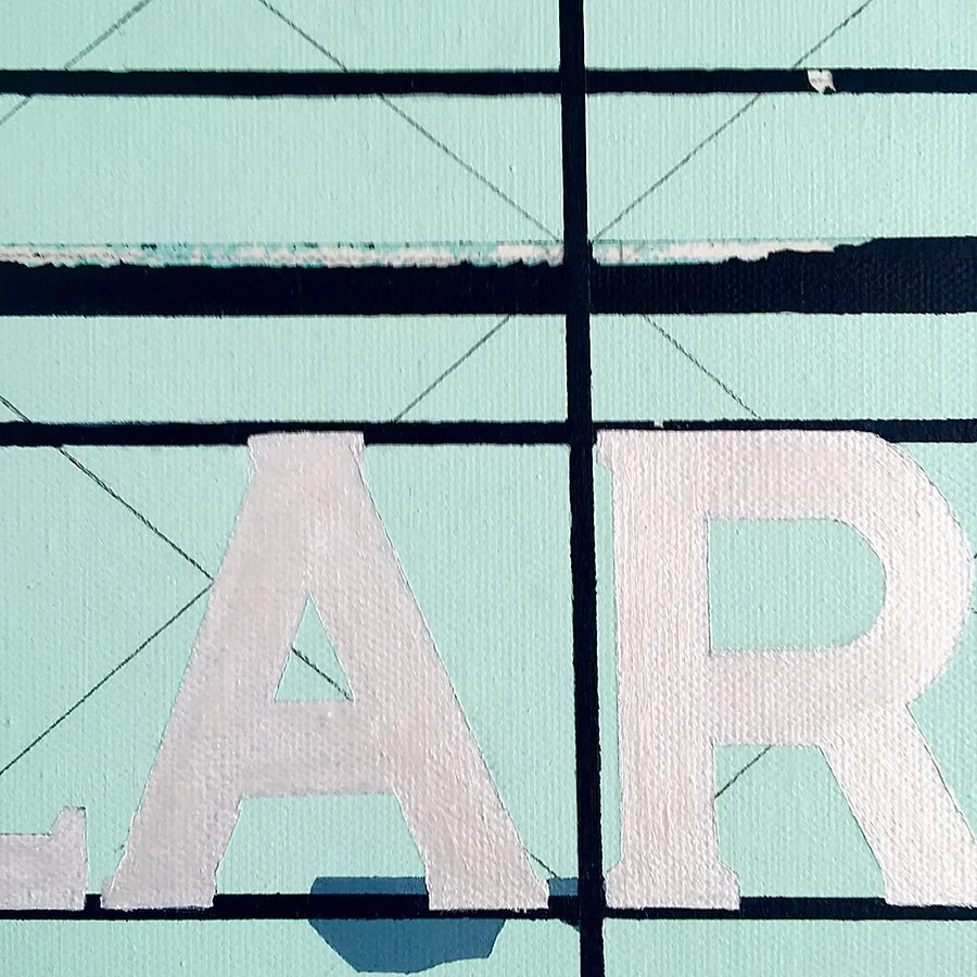 Close-up of an outdoor sign with partially visible white letters on a mint green background, divided by black grid lines.
